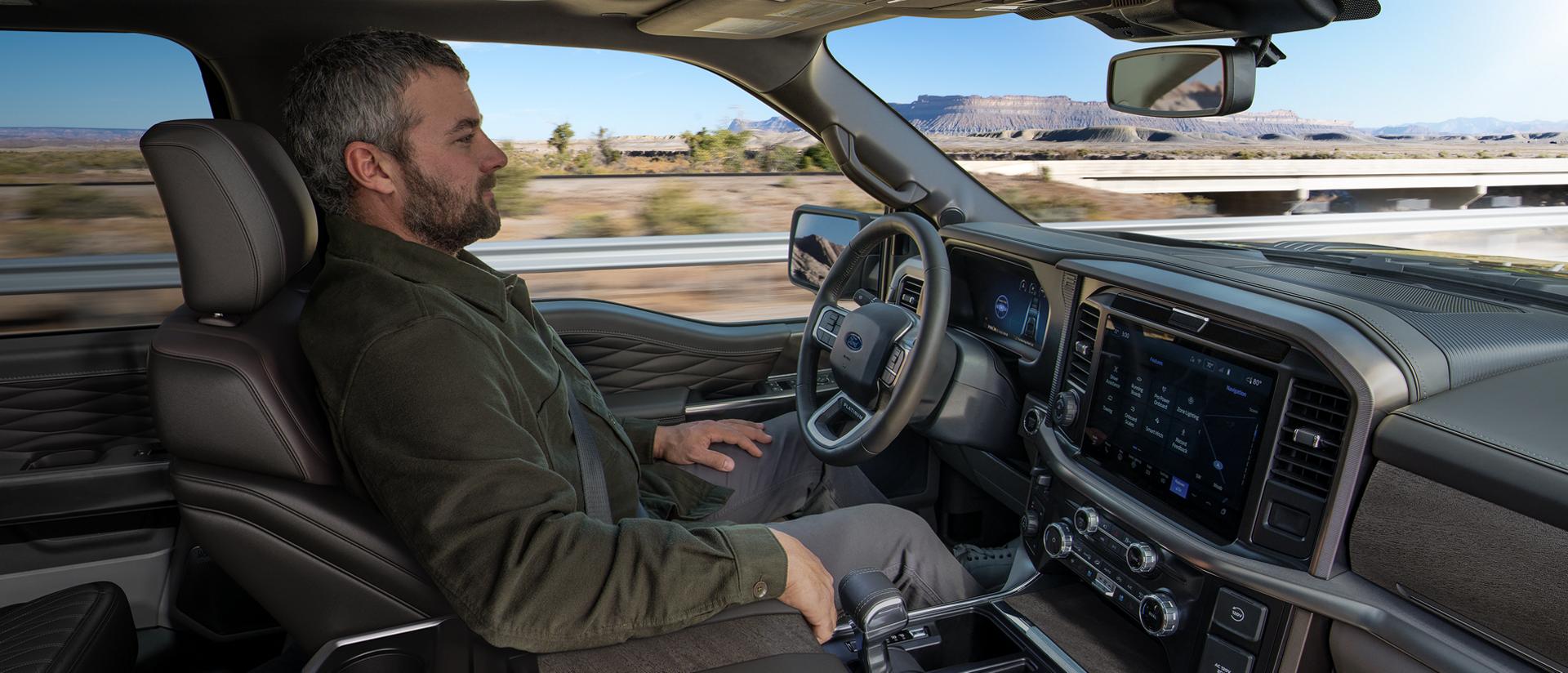 Un homme utilise la fonction de conduite sur autoroute mains libres BlueCruise