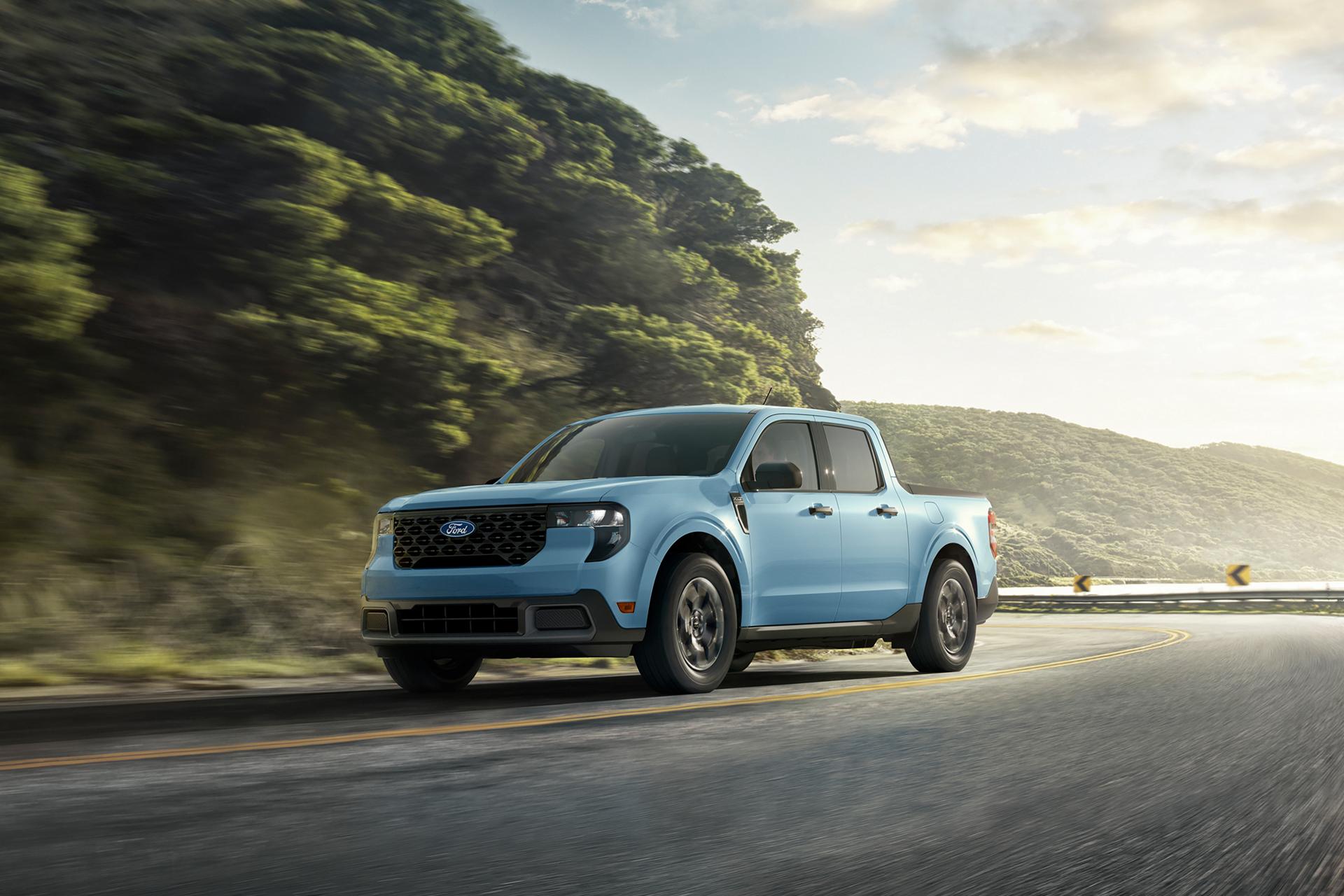 Un Ford Maverick® 2026 circulant sur une autoroute sinueuse près d’un lac de montagne