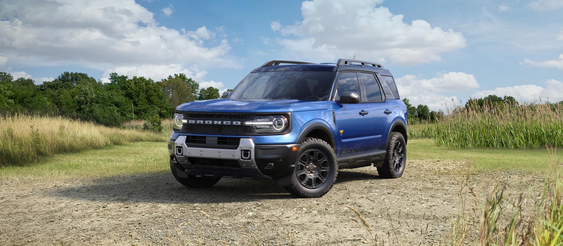 Le VUS Ford Bronco Sport® 2026 stationné sur une zone de gravier avec des arbres en arrière-plan