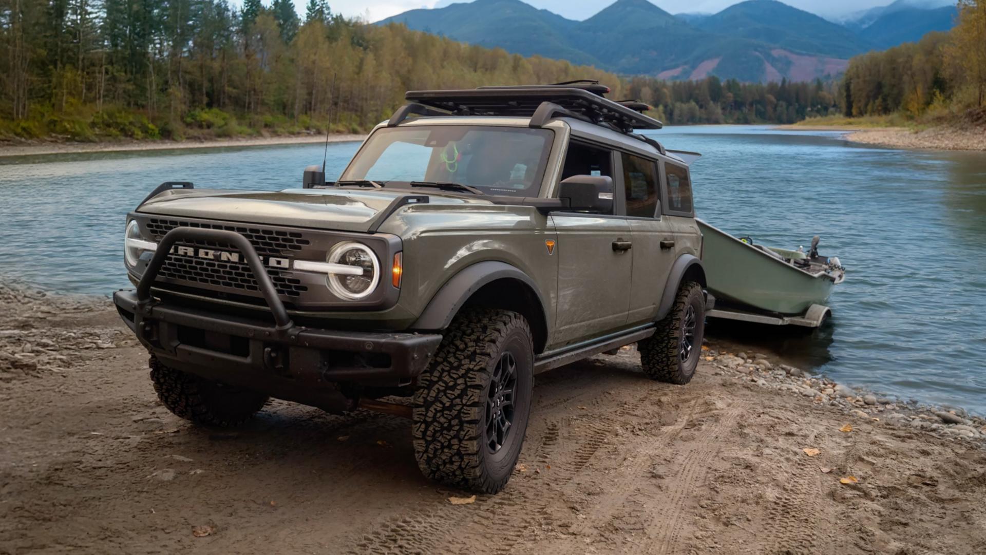 Un VUS Ford Bronco® 2026 tirant un bateau sur une remorque hors d’un lac de montagne