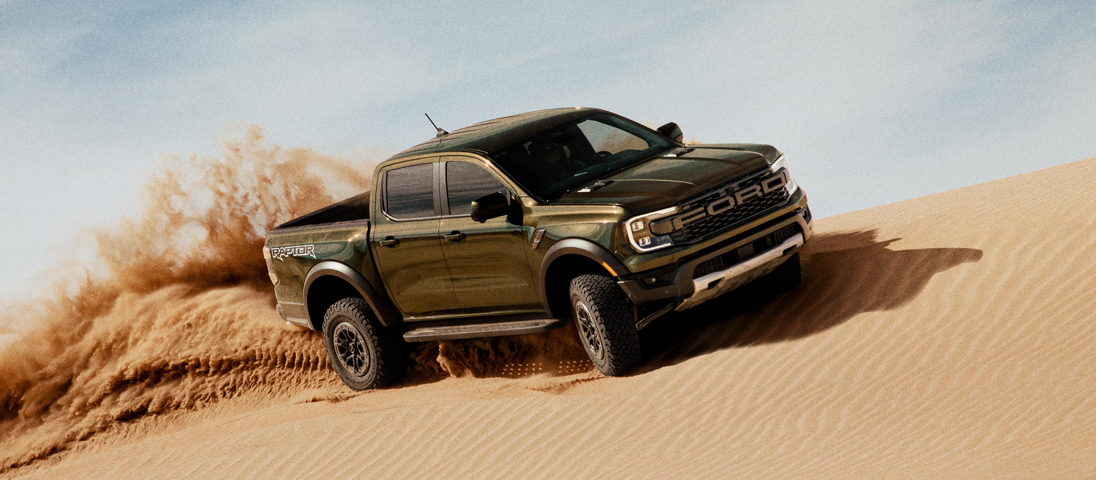 Camion Ford Ranger® Raptor® 2026 soulevant du sable alors qu’il est conduit sur une dune de sable