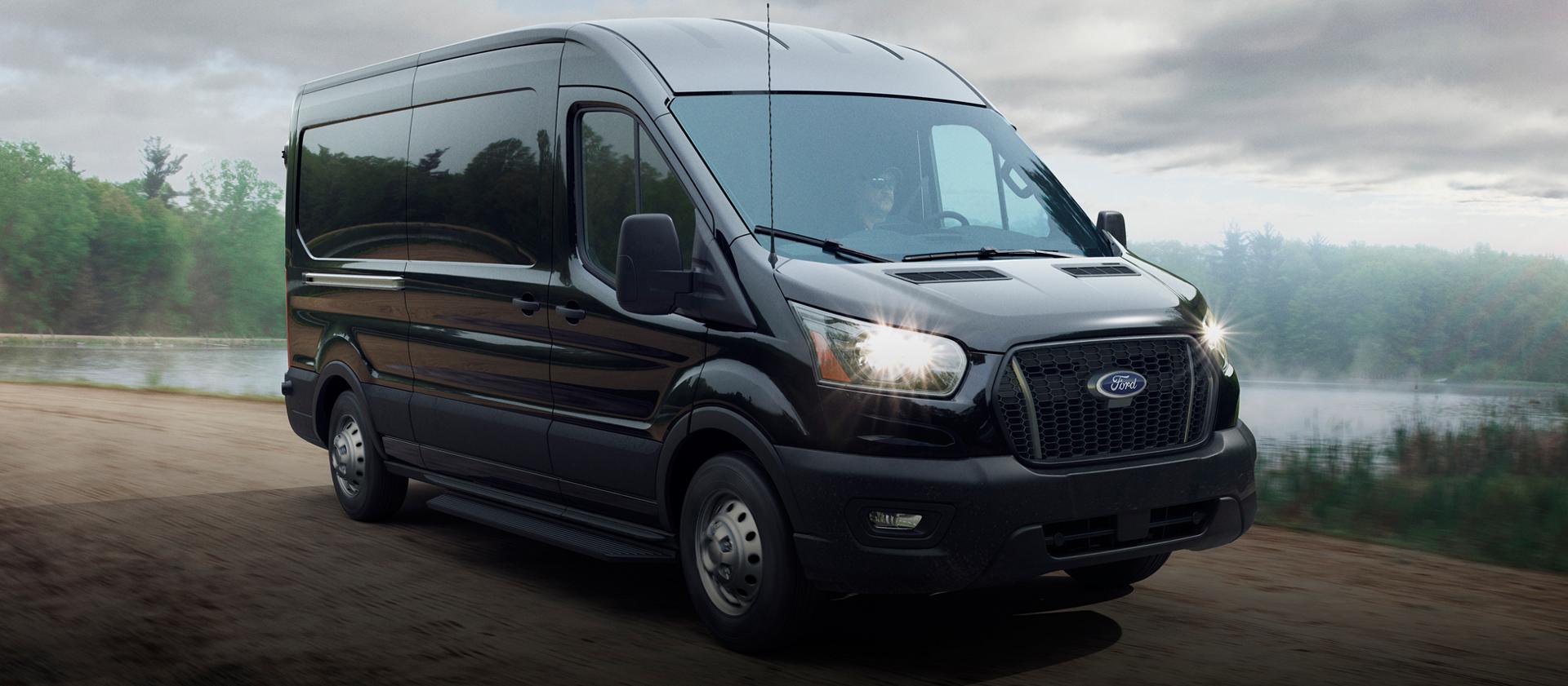 Une fourgonnette Ford Transit® 2026 conduit près d’un lac