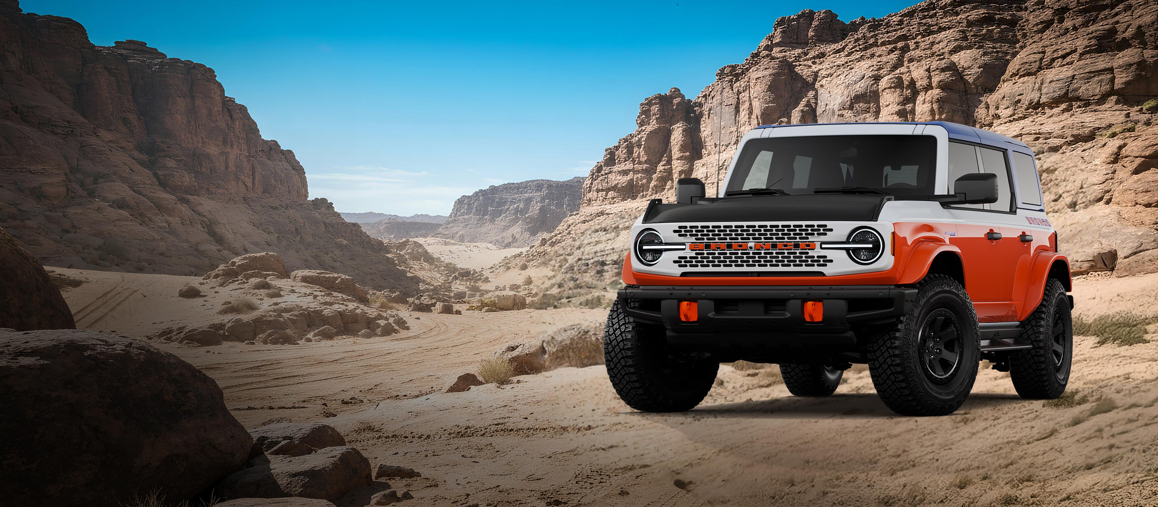 Un modèle Ford Bronco® Stroppe 2026 montré en blanc Oxford stationné sur une étendue rocheuse