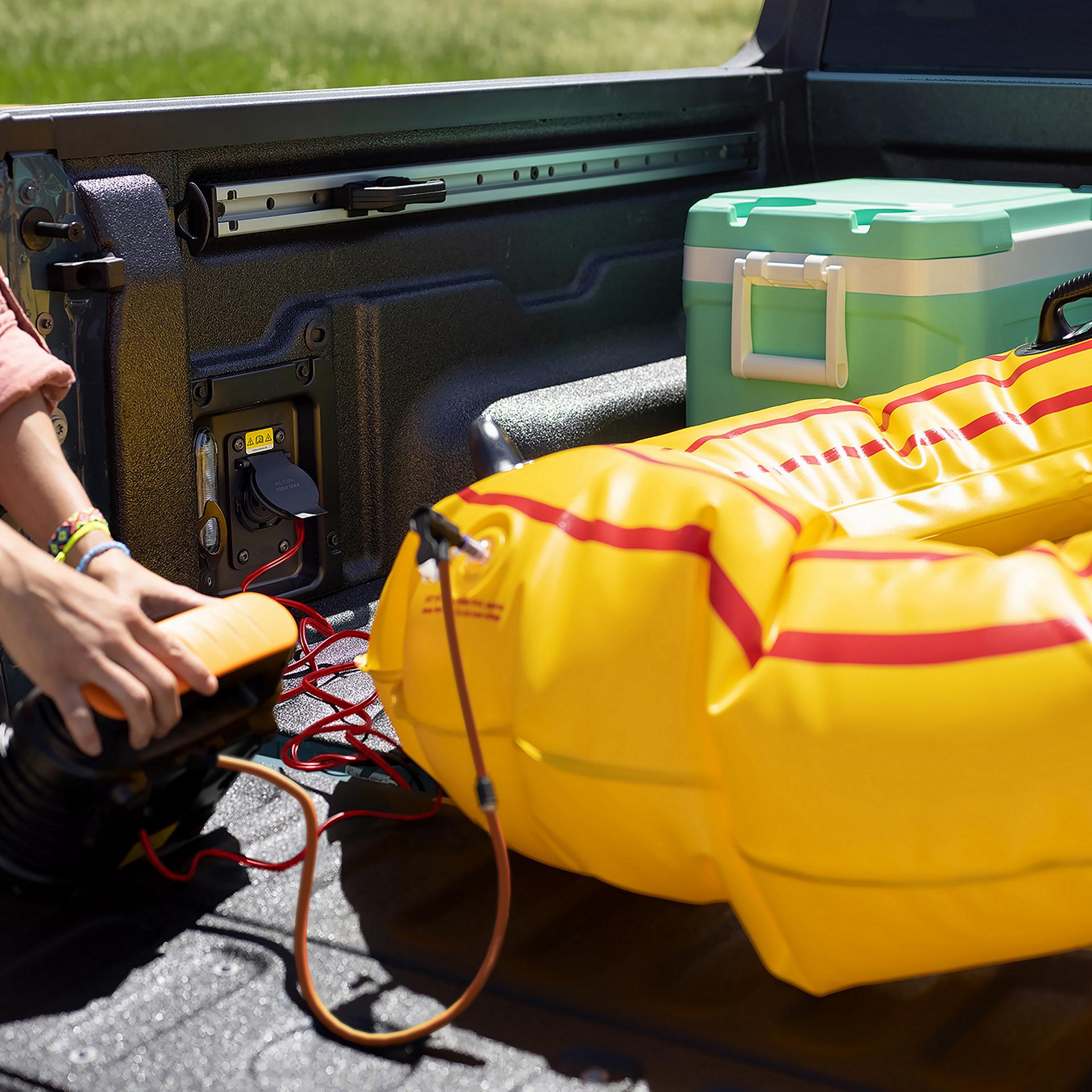 Une personne utilisant la fonction Pro Power Onboard™ – prise de 400 watts pour gonfler un tube flottant.