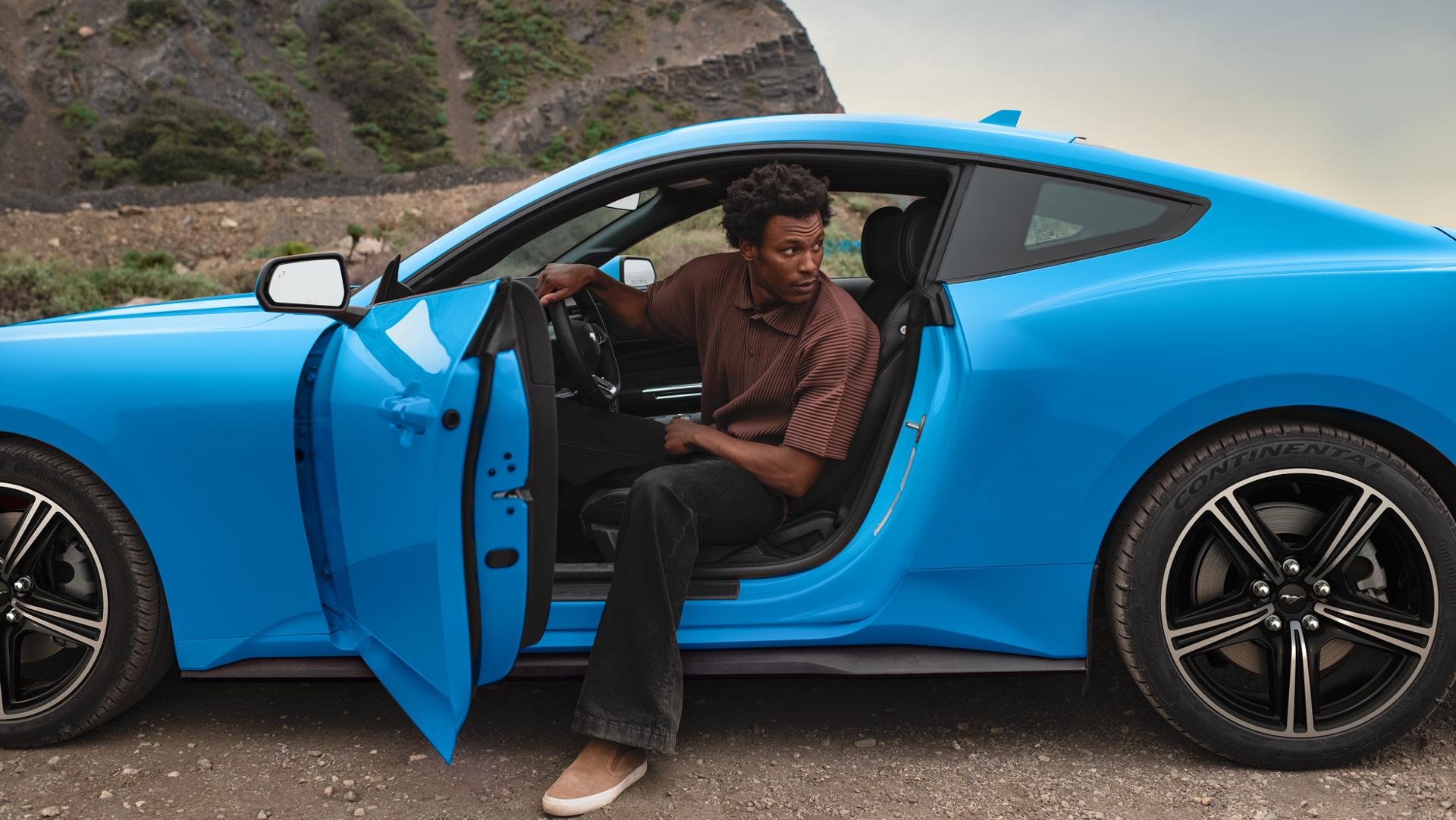 Personne sortant d’une Ford Mustang® Coupé 2025 stationnée dans le désert