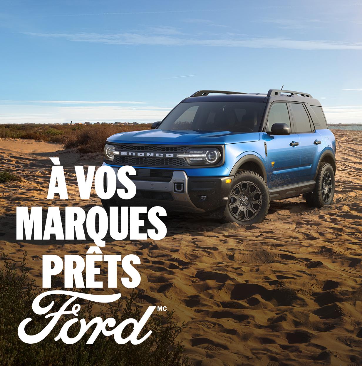 Vue de trois quarts avant d'un Ford Bronco Sport bleu garé dans le désert. À vos marques, prêts, Ford.