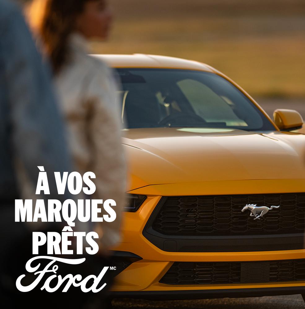 Une Ford Mustang® GT Premium Coupé jaune 2026 avec une femme au premier plan