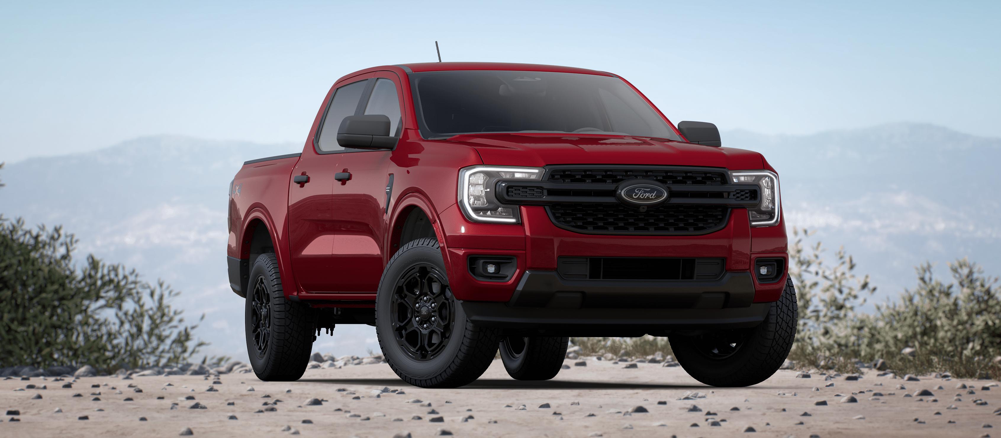 Un Ford Ranger® 2025 avec ensemble décor noir en option stationné dans un champ au pied des montagnes