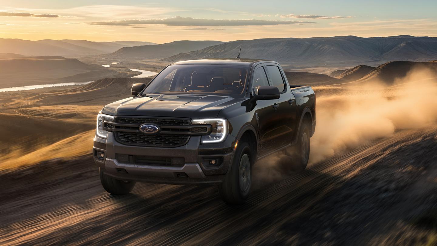 Un Ford Ranger® XLT 2026 avec ensemble décor sport conduit dans un désert au crépuscule