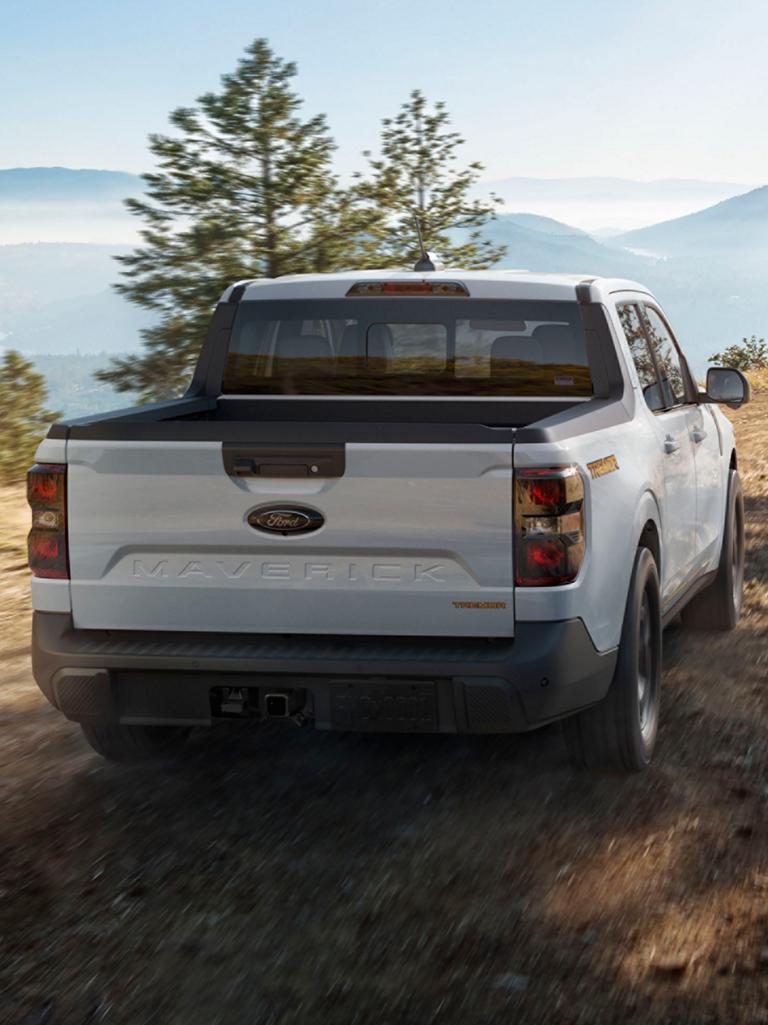 Vue arrière d’un Ford Maverick® 2026 conduisant sur un chemin de terre