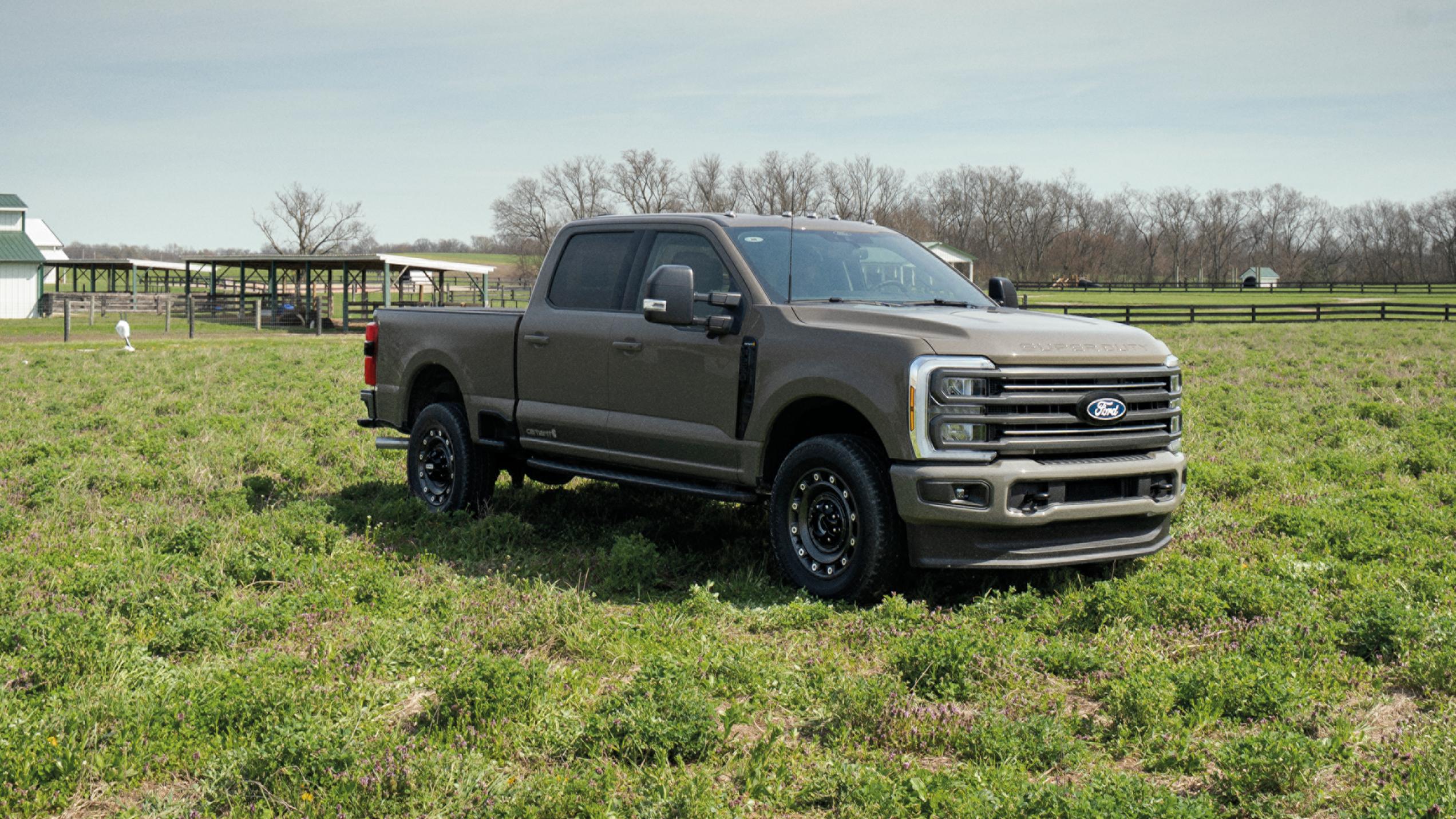 Un modèle Ford Super Duty® F-250® XLT 2027 équipé de l'ensemble Super Duty Carhartt® garé dans un champ herbeux