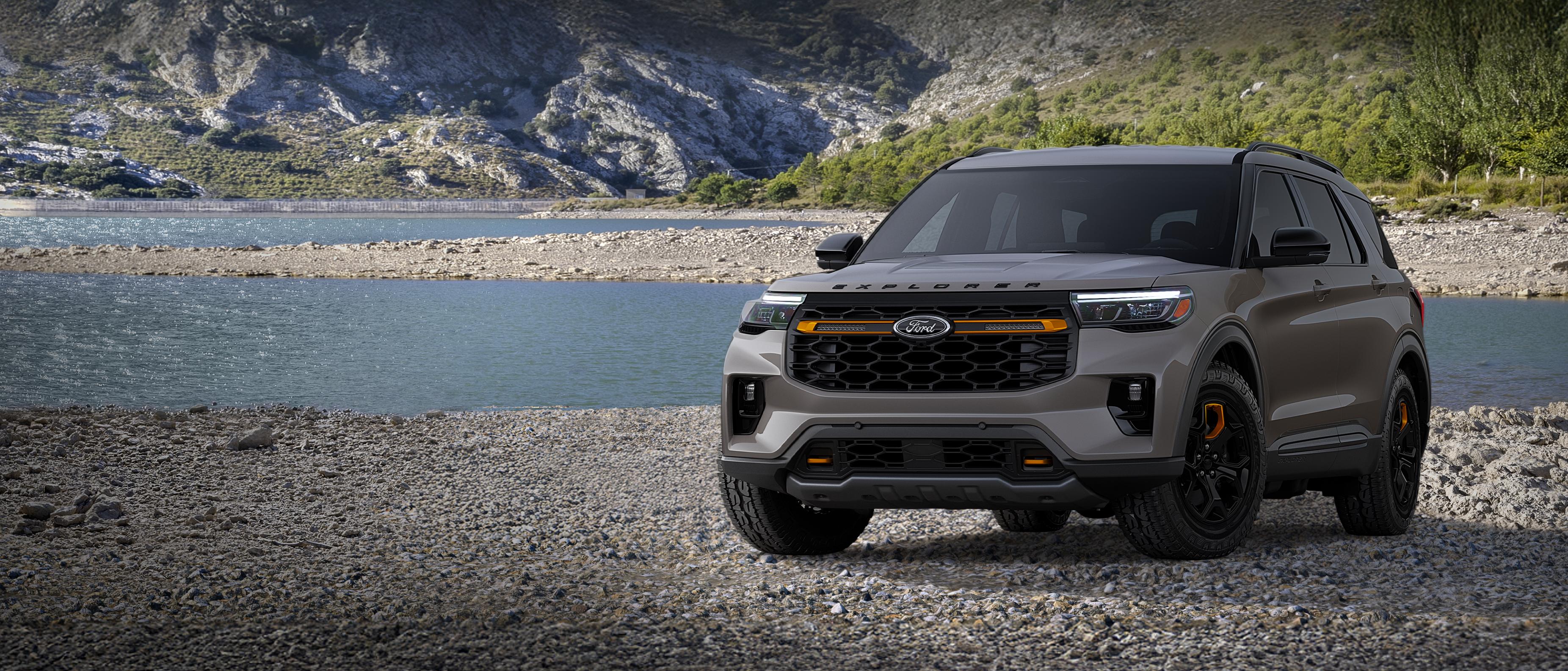 Un modèle Ford Explorer® Tremor 2026 stationné sur une étendue rocheuse, près d’un lac de montagne