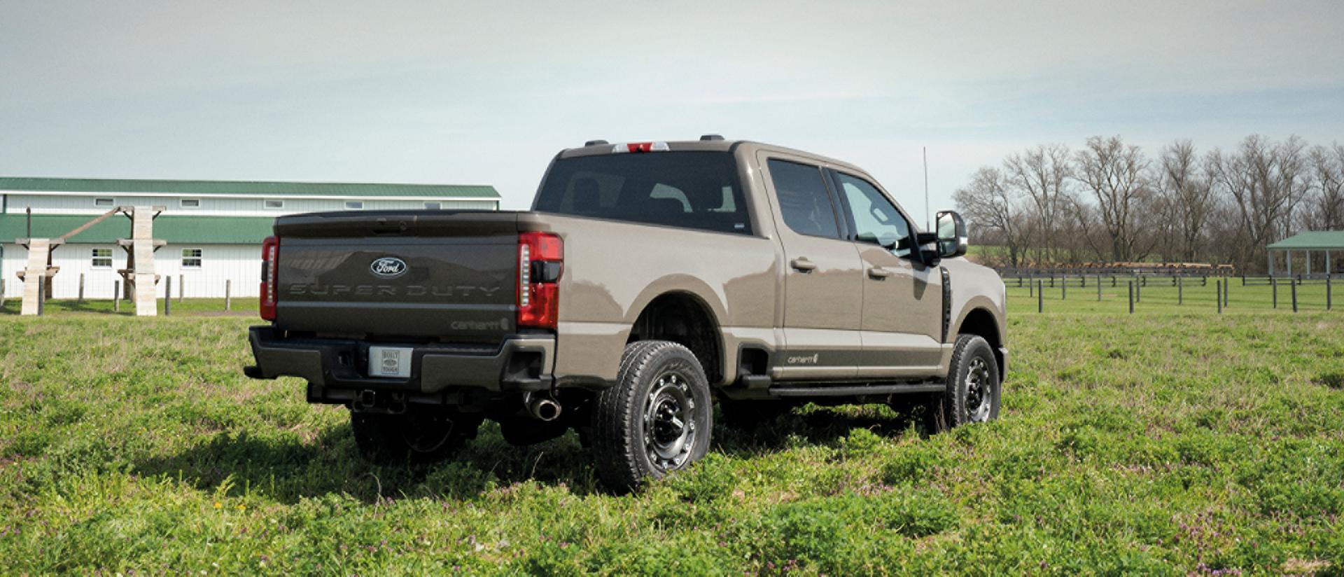 Une personne portant des bottes utilise le marchepied d’angle arrière pour monter dans le caisson de son camion Ford Super Duty® 2027.