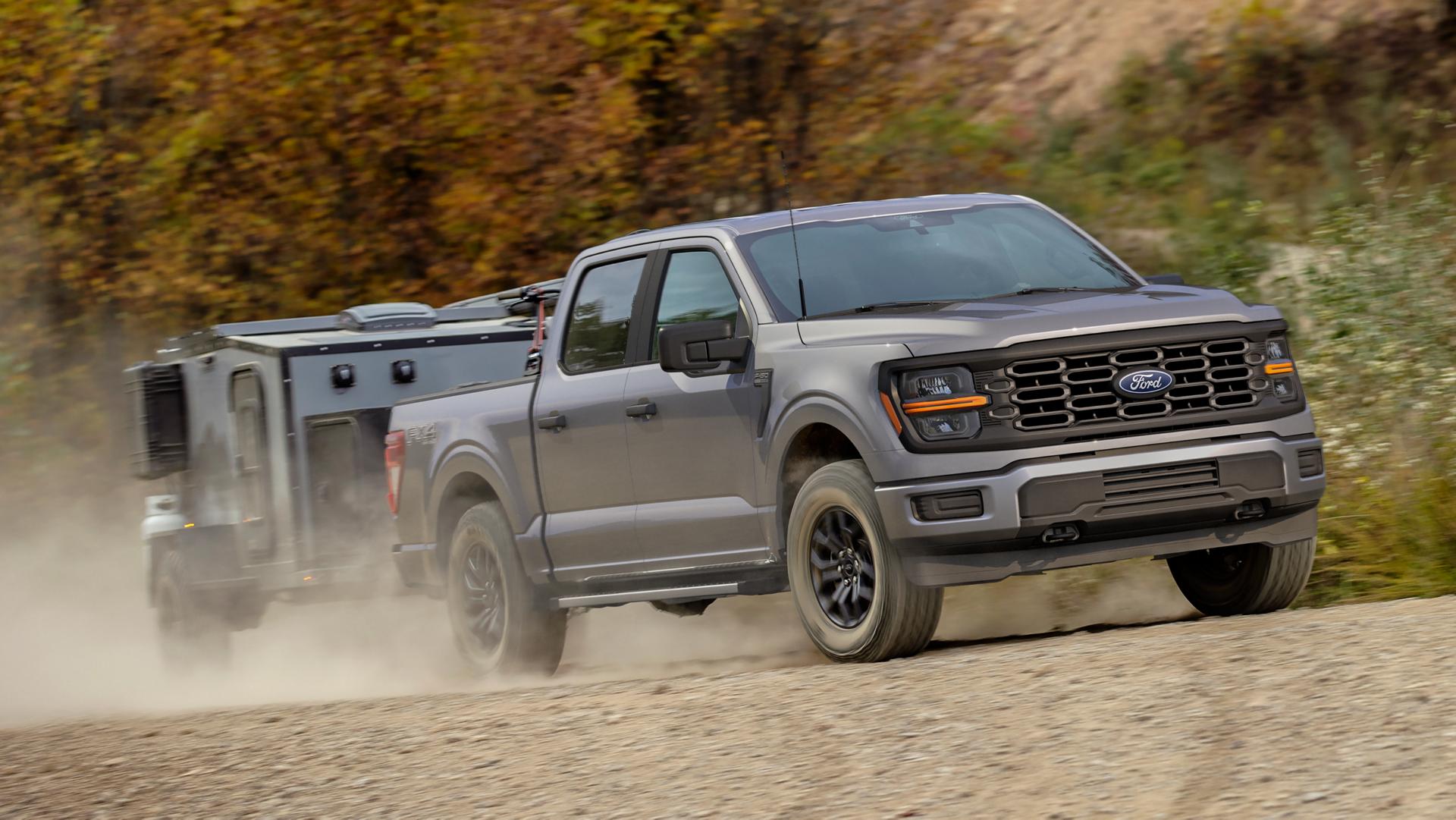 Modèle Ford F-150® FX4® 2025 tirant un petite roulotte sur une route de terre