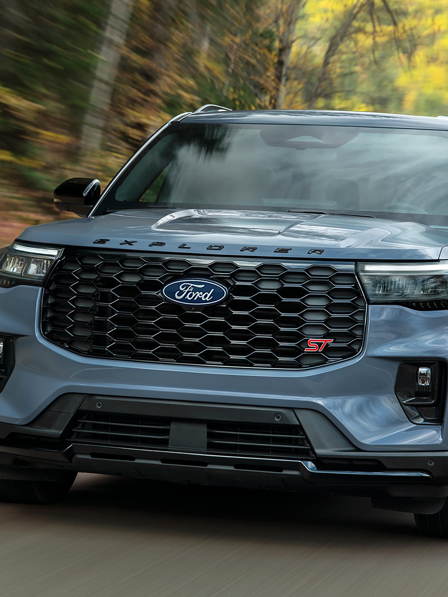 Un modèle Ford Explorer® ST 2027 circulant sur une autoroute dans la forêt