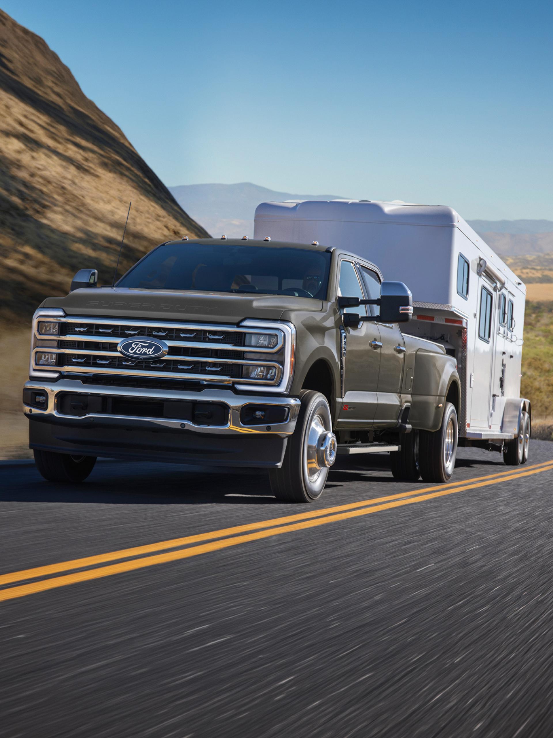Camion Ford Super Duty® F-350® Lariat® 2027 tirant une grande caravane sur une route de montagne