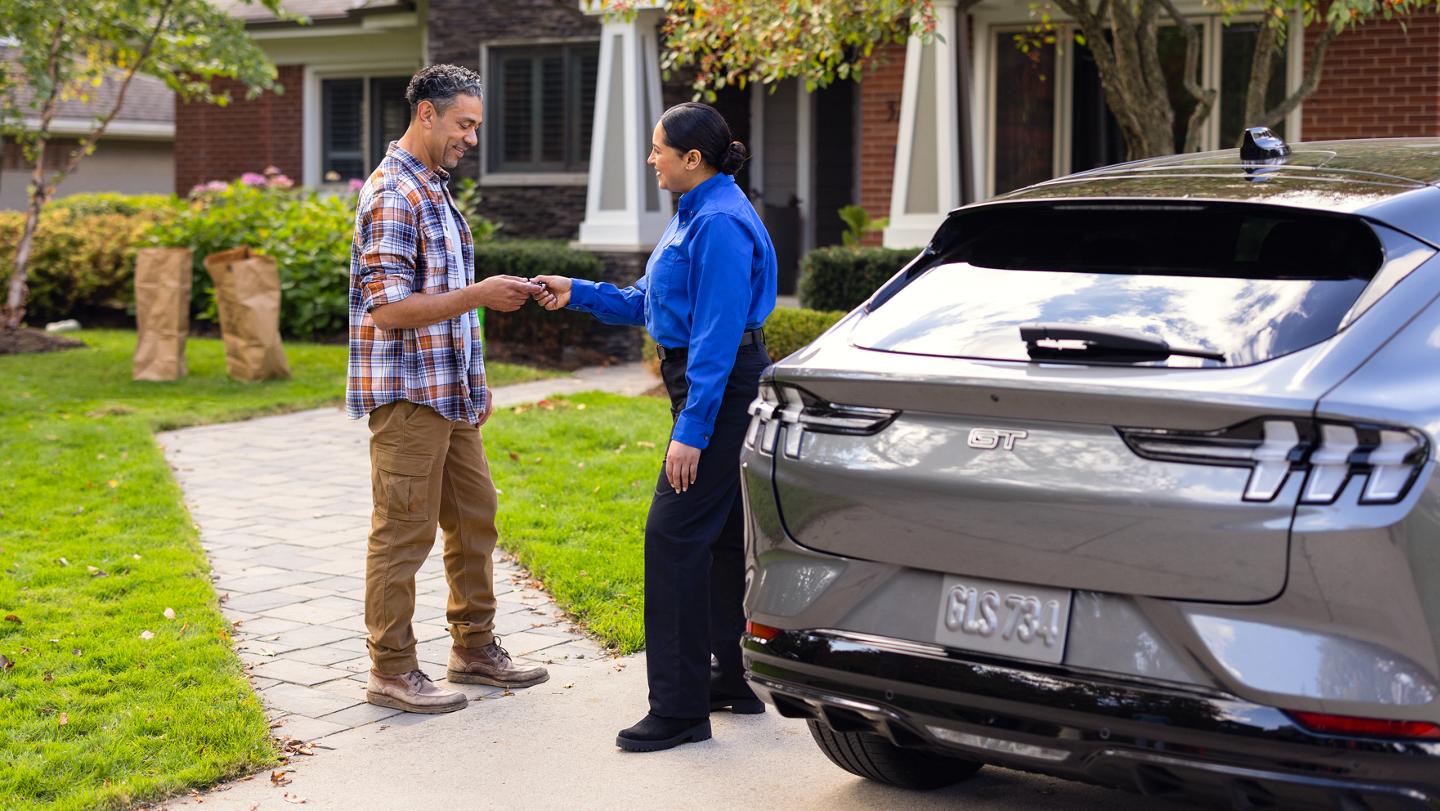 Un client tend les clés de son véhicule à une employée de Service Ford.