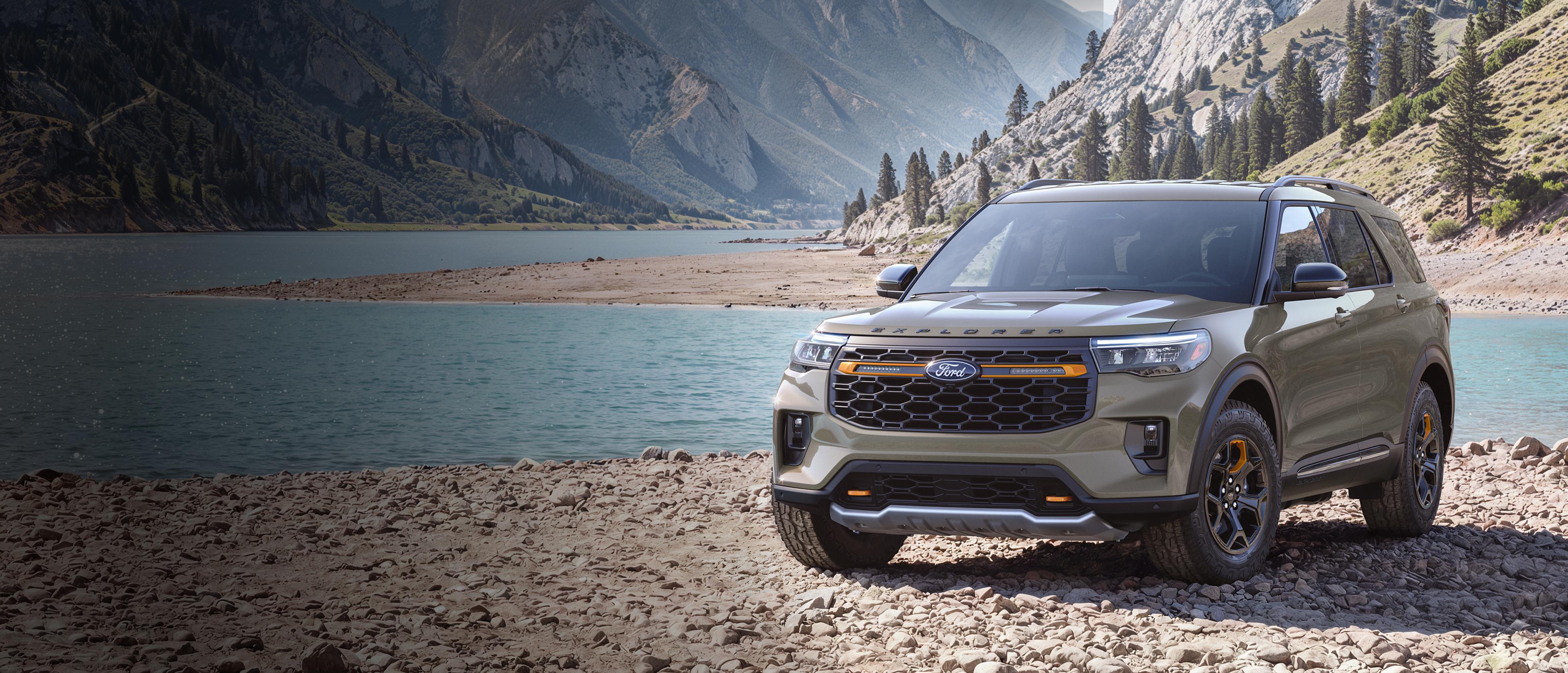 Un modèle Ford Explorer® Tremor® 2027 stationné sur une étendue rocheuse, près d’un lac de montagne