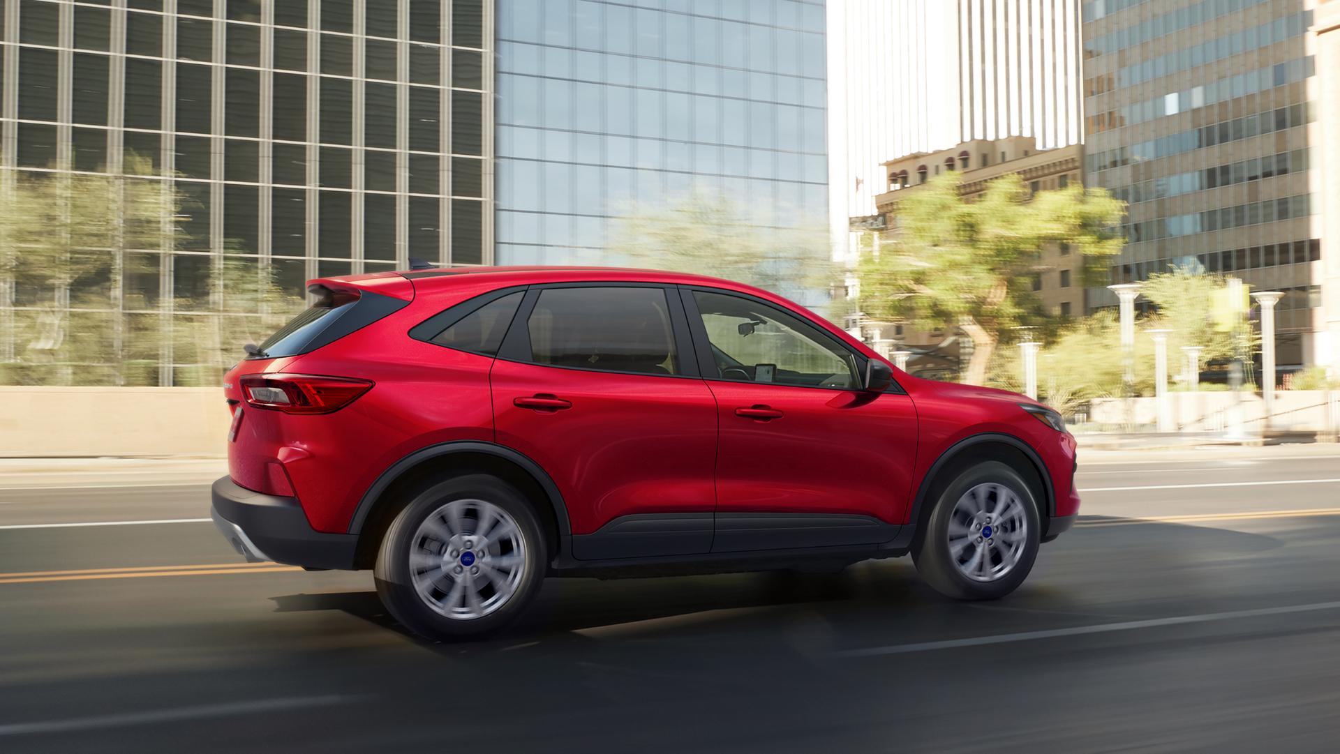 Le VUS Ford Escape® 2026 en rouge rapide conduit sur la rue d’une ville