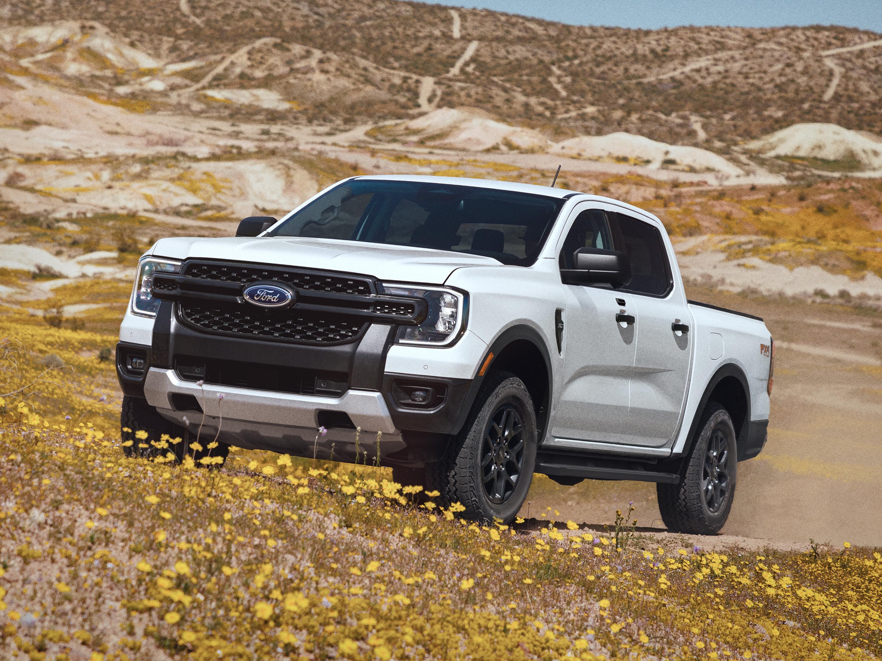 Modèle Ford Ranger® Raptor® 2026 circulant sur un flanc de montagne gazonné