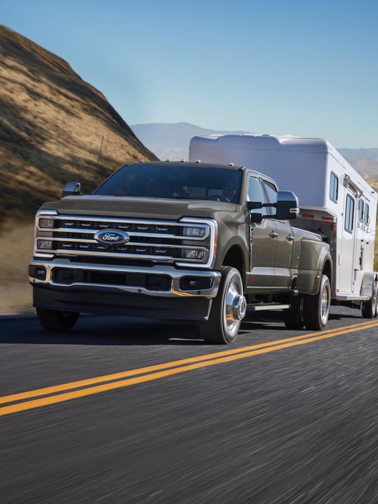 Ford Super Duty® F-350® Lariat® 2026 gris marais roulant sur une route pavée avec une grande remorque