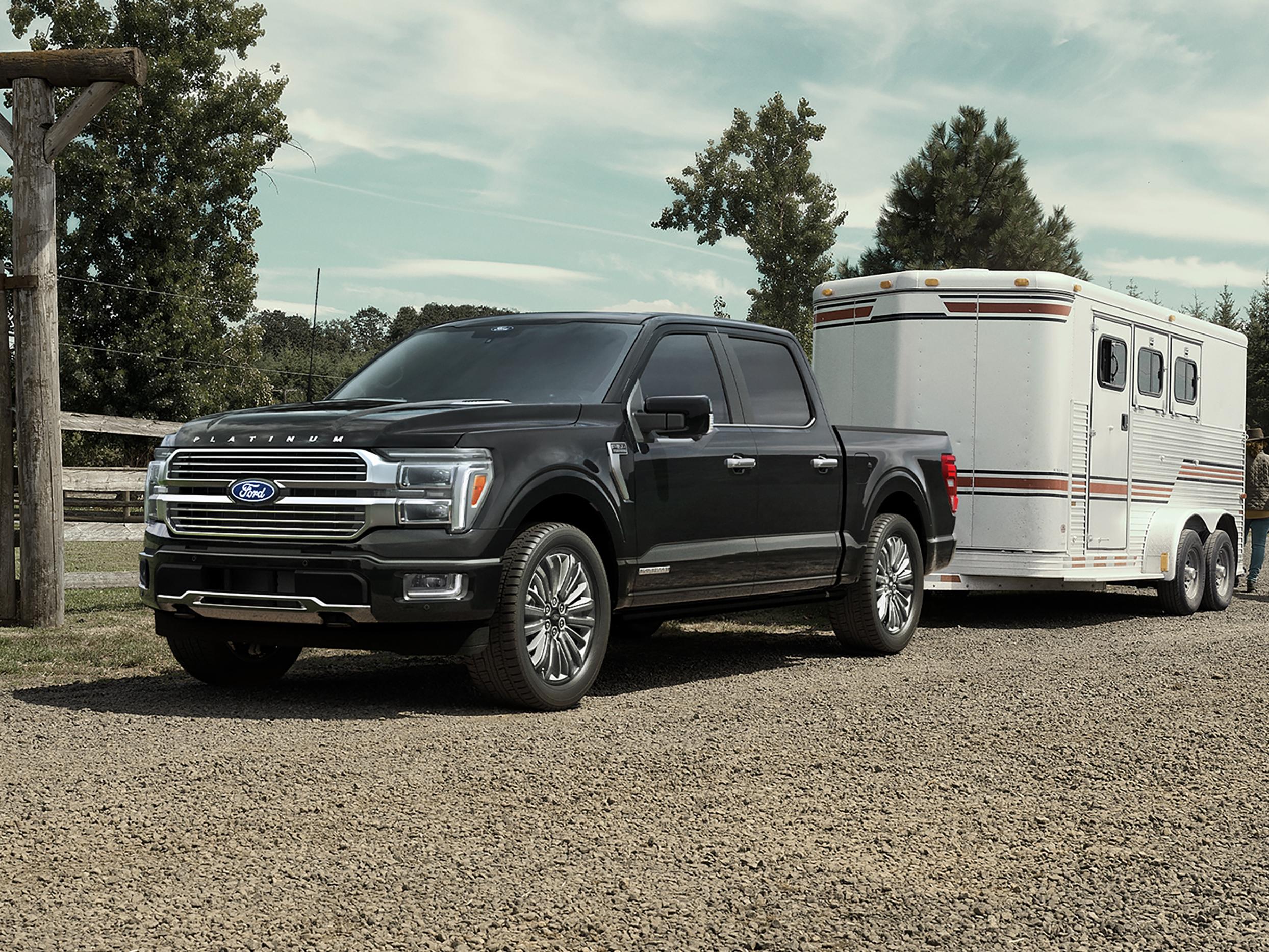 Ford F-150® Platinum® 2025 noir agate garé avec une remorque dans une ferme équestre