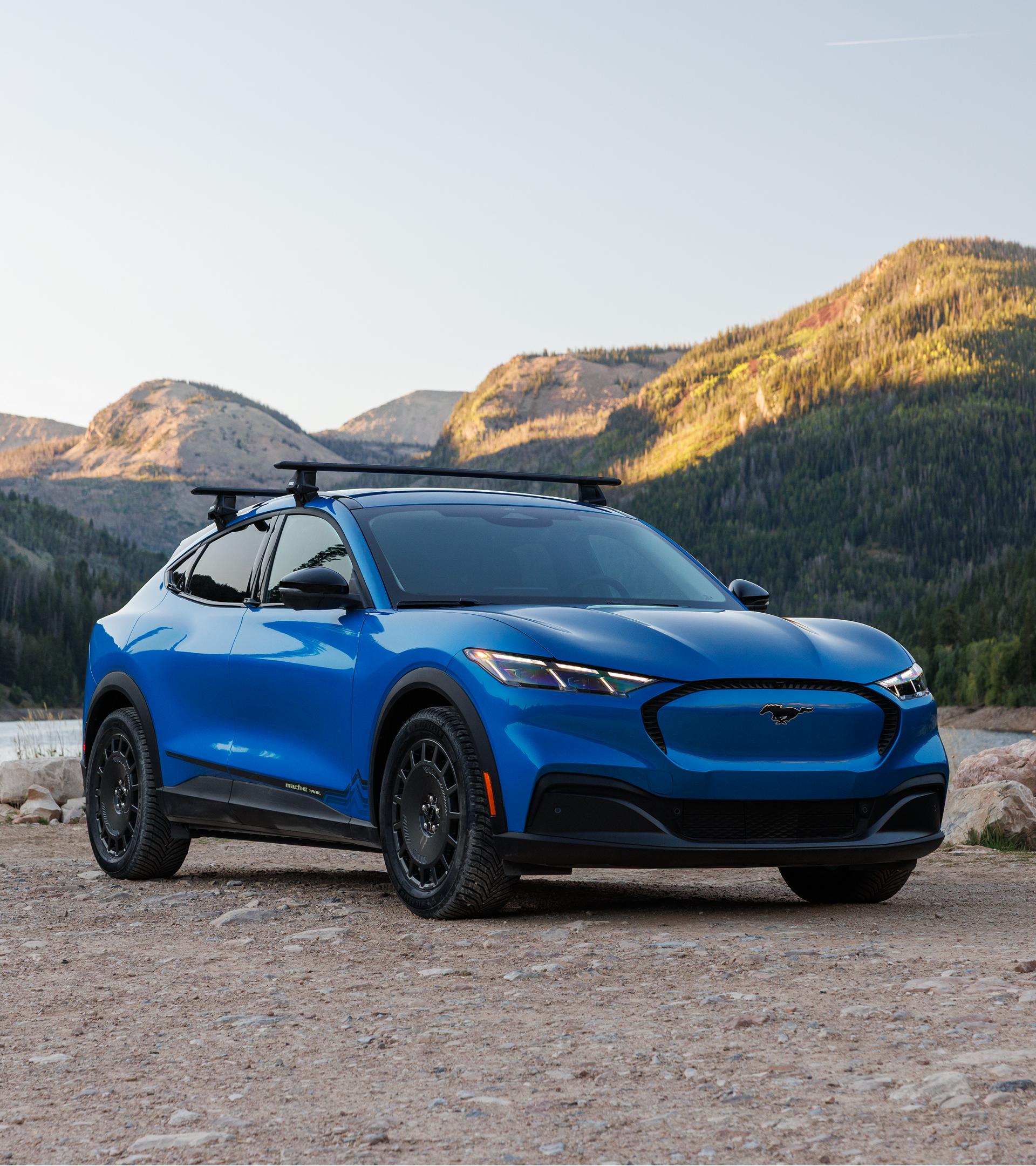 Une Mustang Mach-E® 2027, équipée de l'ensemble sentier en option et du porte-vélos Ford disponible en option, garée hors route