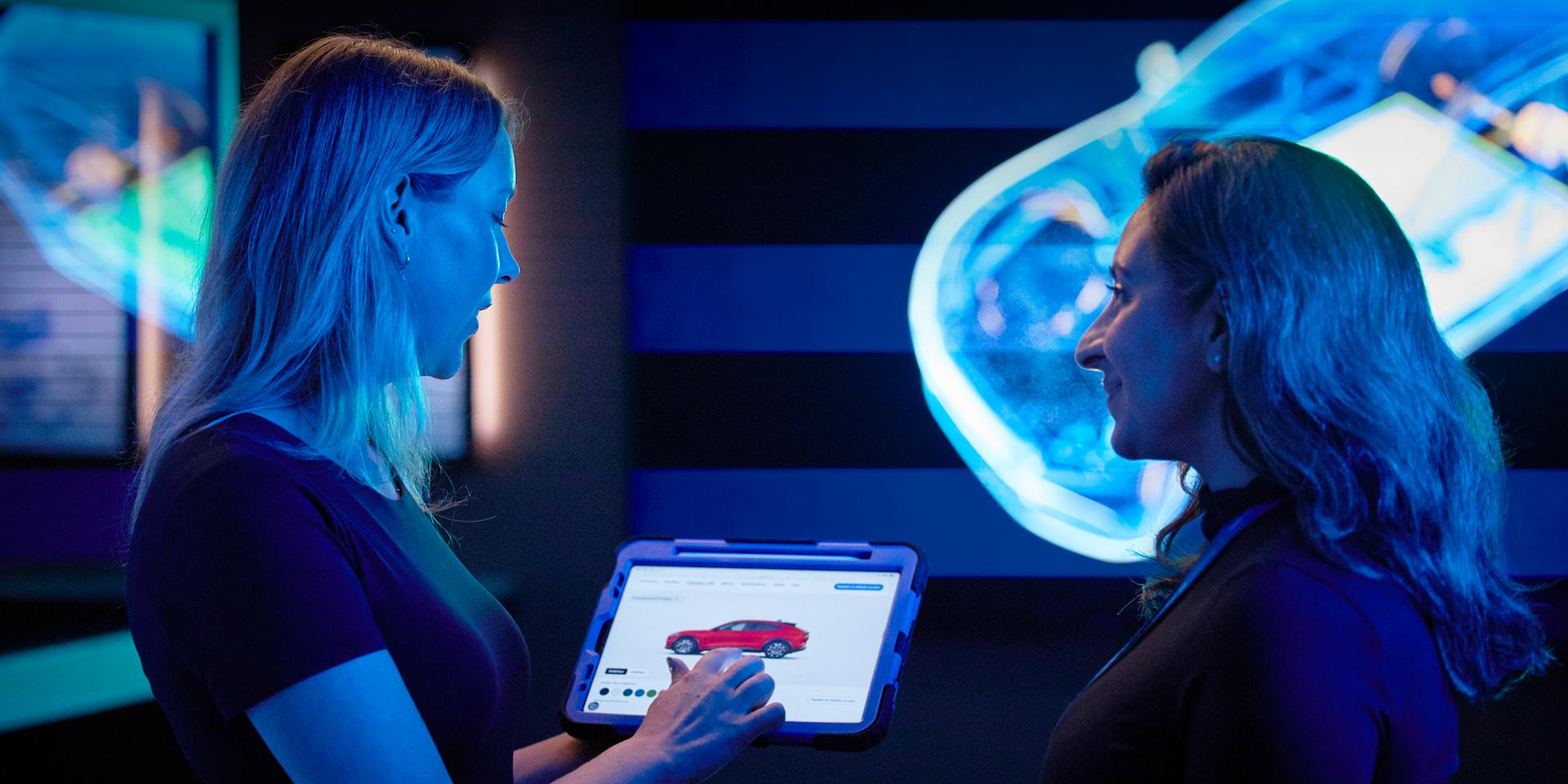 Deux employés de Ford examinent une image sur une tablette.