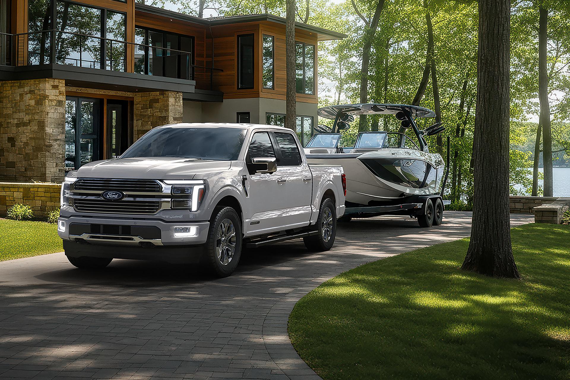 Modèle Ford F-150® Platinum 2026 avec l’ensemble satin tirant une petite remorque sur une route de campagne