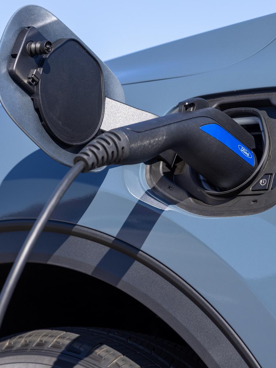 Véhicule Ford avec câble de recharge branché.
