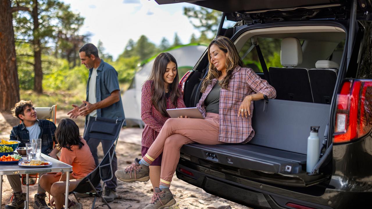 Deux personnes utilisant le dossier du hayon en option d’un VUS Ford Expedition® 2027