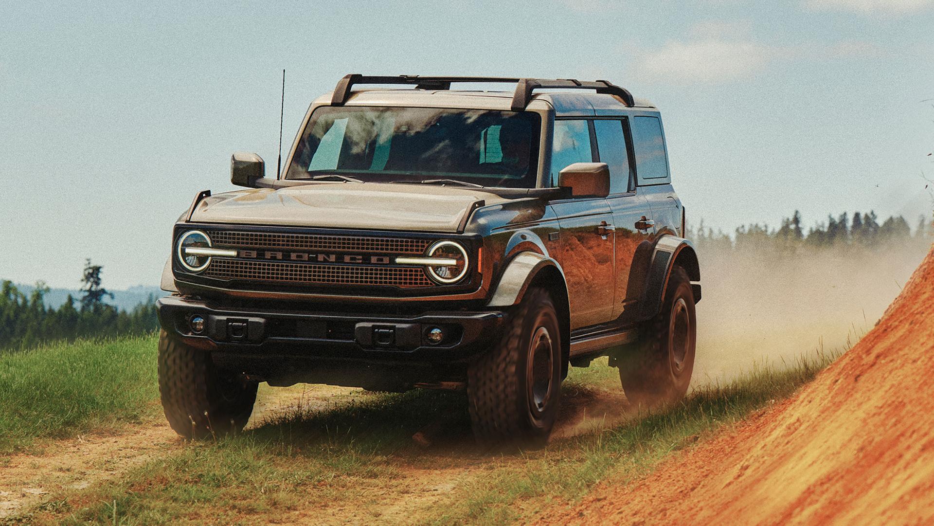 Un VUS Ford Bronco® Filson 2027 circulant sur un chemin de terre près d'une colline