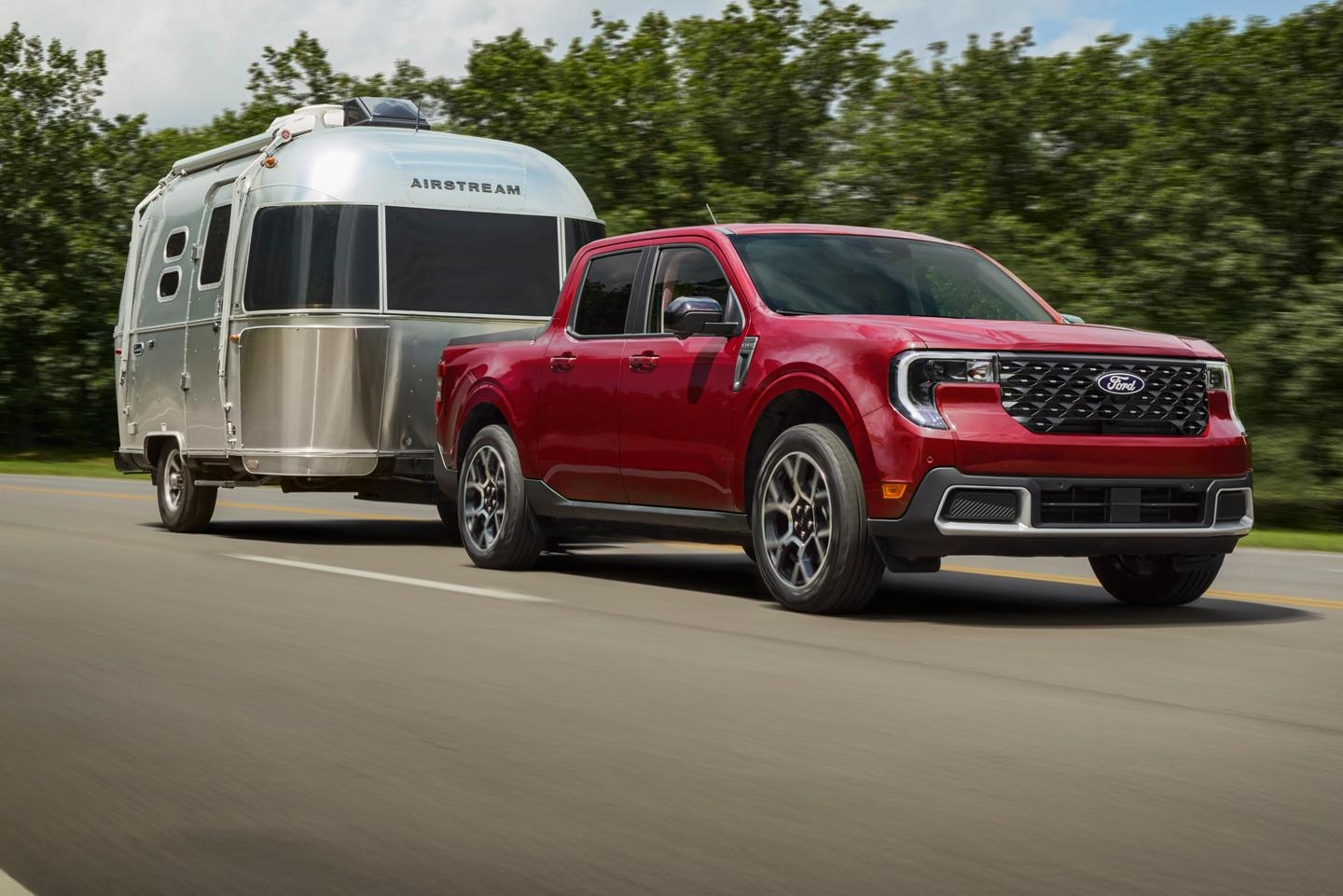 Un Ford Maverick roule sur l'autoroute en tractant une caravane Airstream.