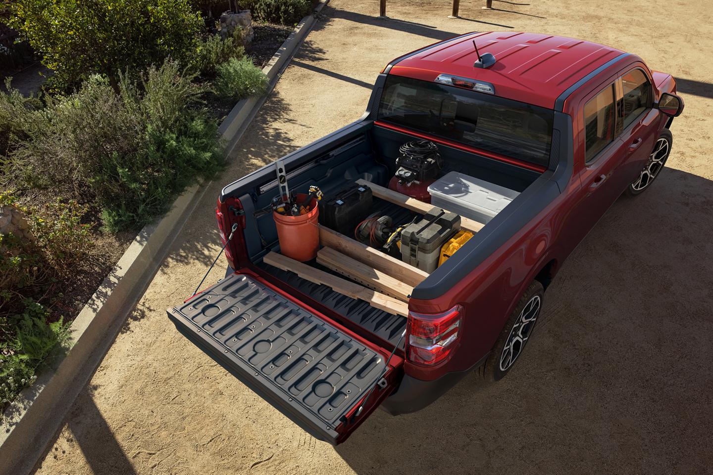 Vue aérienne d’un camion Ford Maverick® 2026 de couleur rouge rubis métallisé, montrant le système de rangement FLEXBED avec des articles dans le caisson.