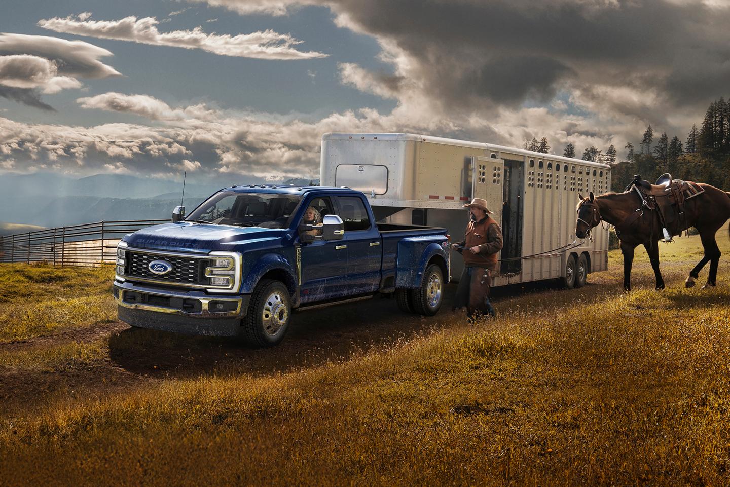 Ford Super Duty® F-350 Lariat® 2026 en bleu argon tirant une remorque sur une route pavée