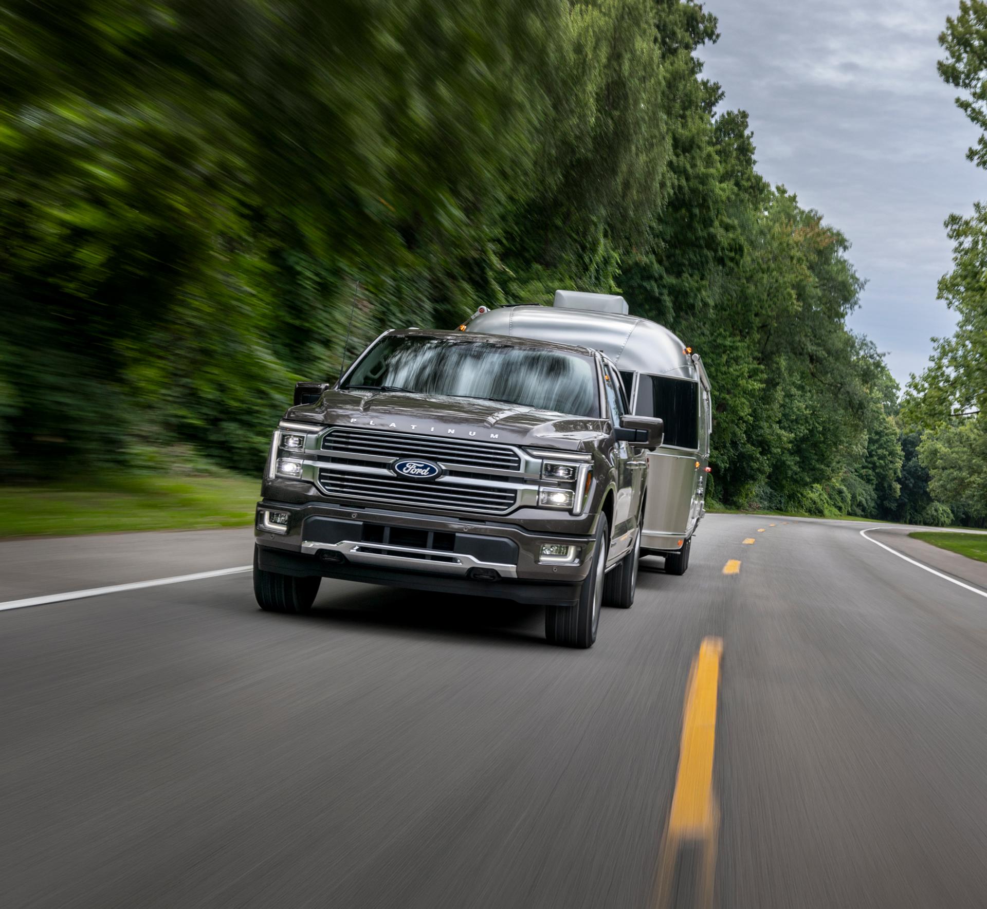Un F-150 2025 tractant une caravane sur une autoroute.