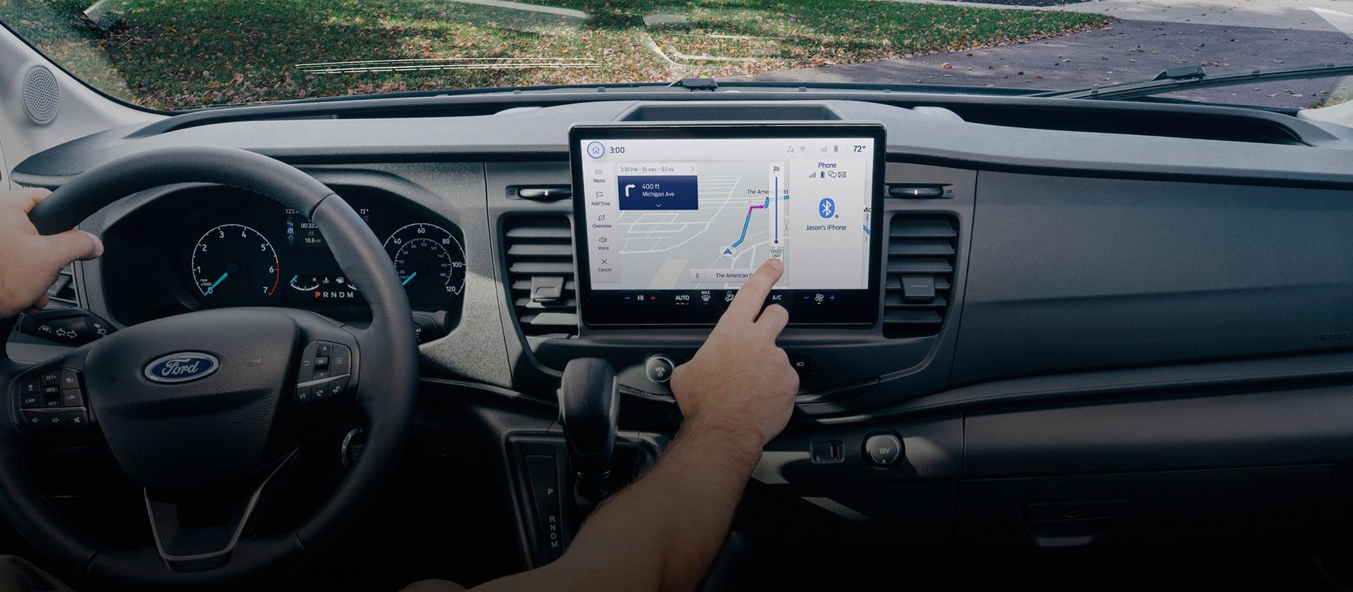 Intérieur d’une fourgonnette Ford Transit® 2025 avec une personne interagissant avec l’écran tactile