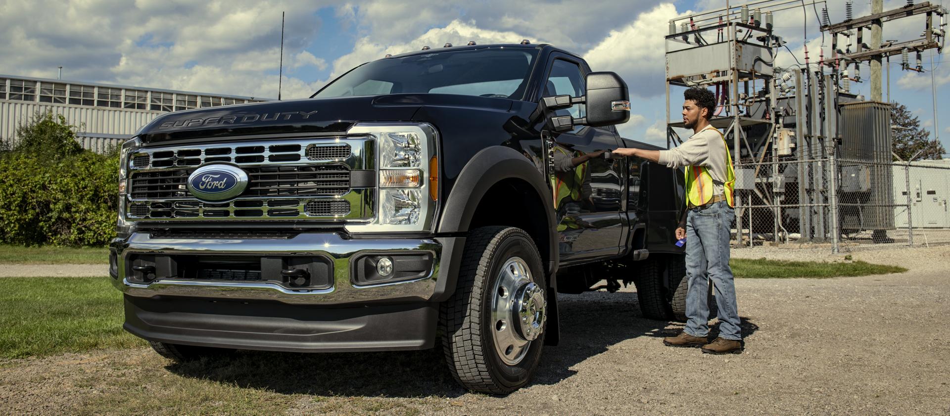 Une personne ouvrant la porte du conducteur de son modèle Ford Super Duty® F-450® XL 2026 avec l’ensemble décor chromé