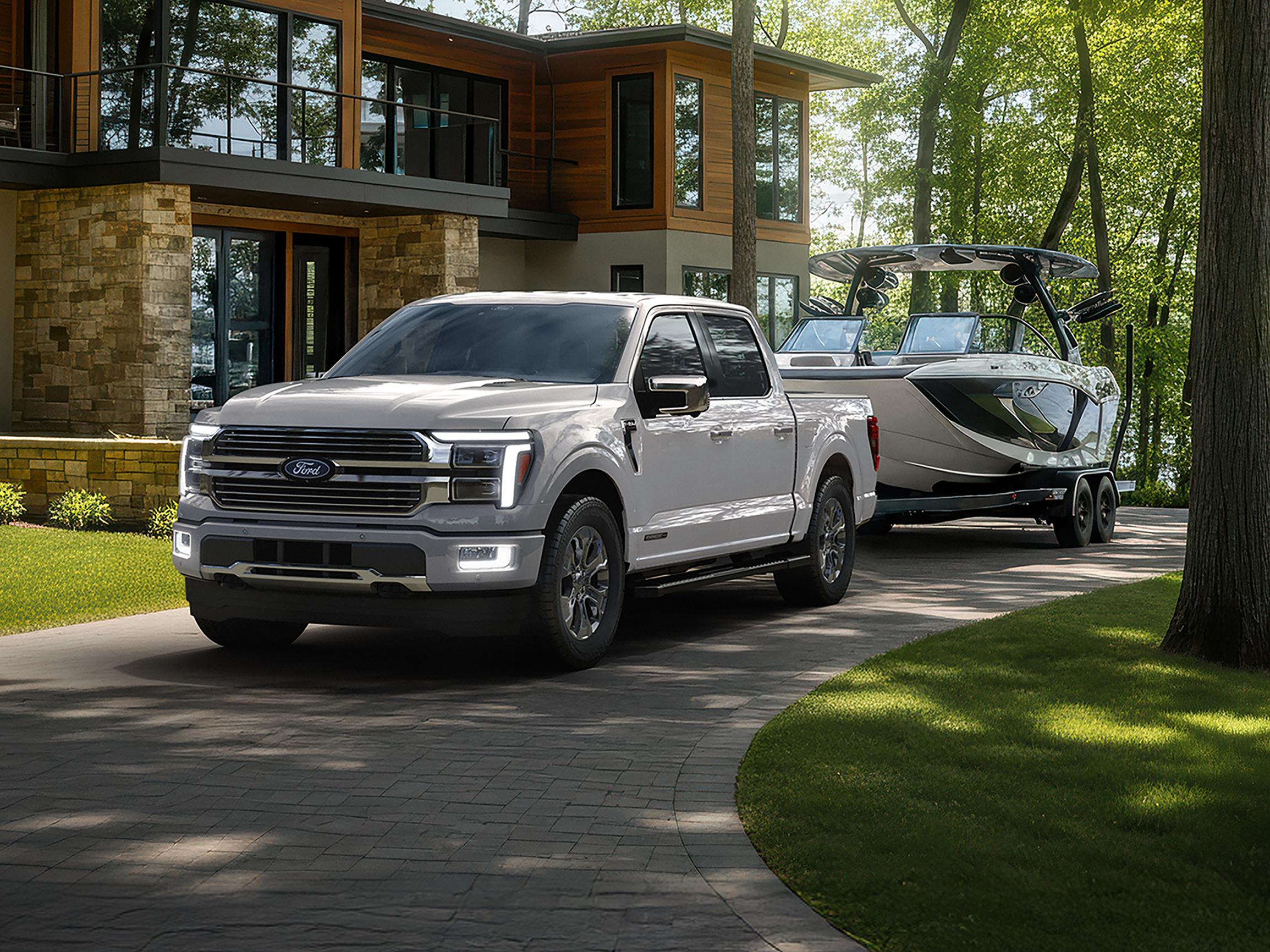 Modèle Ford F-150® Platinum® 2026 fixé à une remorque de bateau stationnée près d’une maison