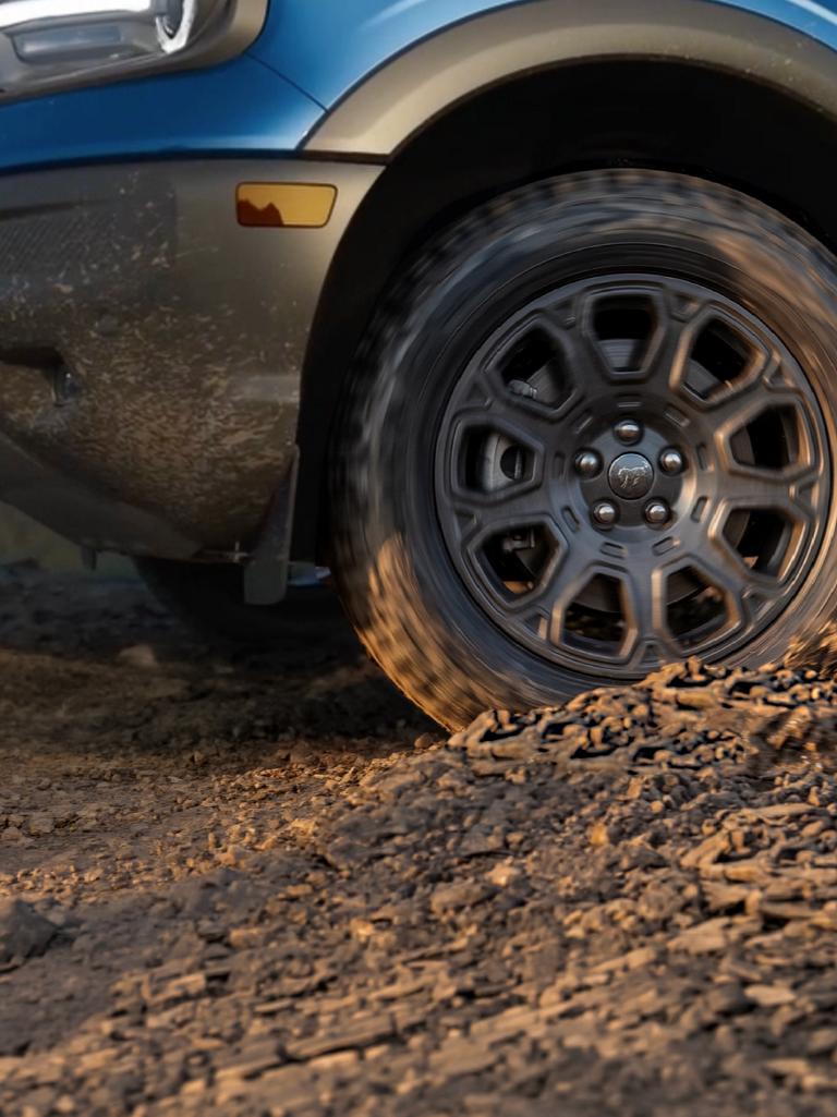 Vue de profil en gros plan d’un pneu tout-terrain et de l’aile avant d’un Bronco Sport®.