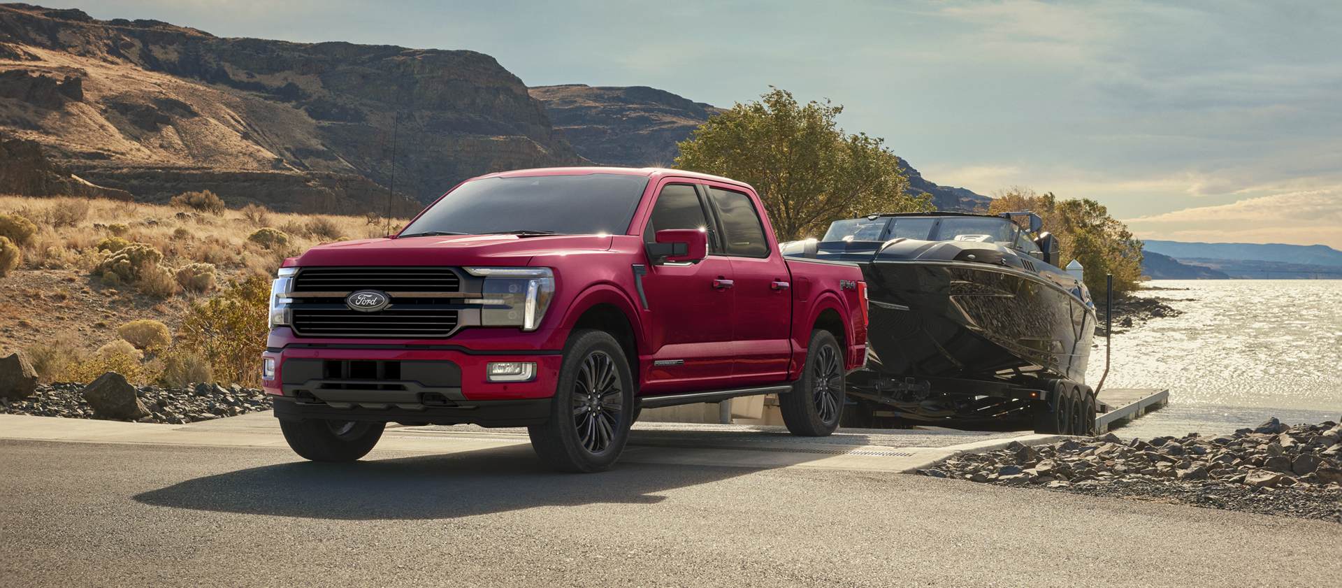 Un F-150 garé au bord de l'eau, avec un bateau attelé.