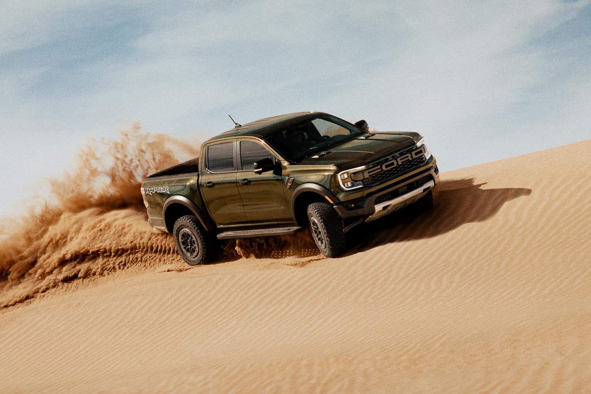 Un modèle Ranger® Raptor® 2025 circulant sur une dune de sable et projetant du sable