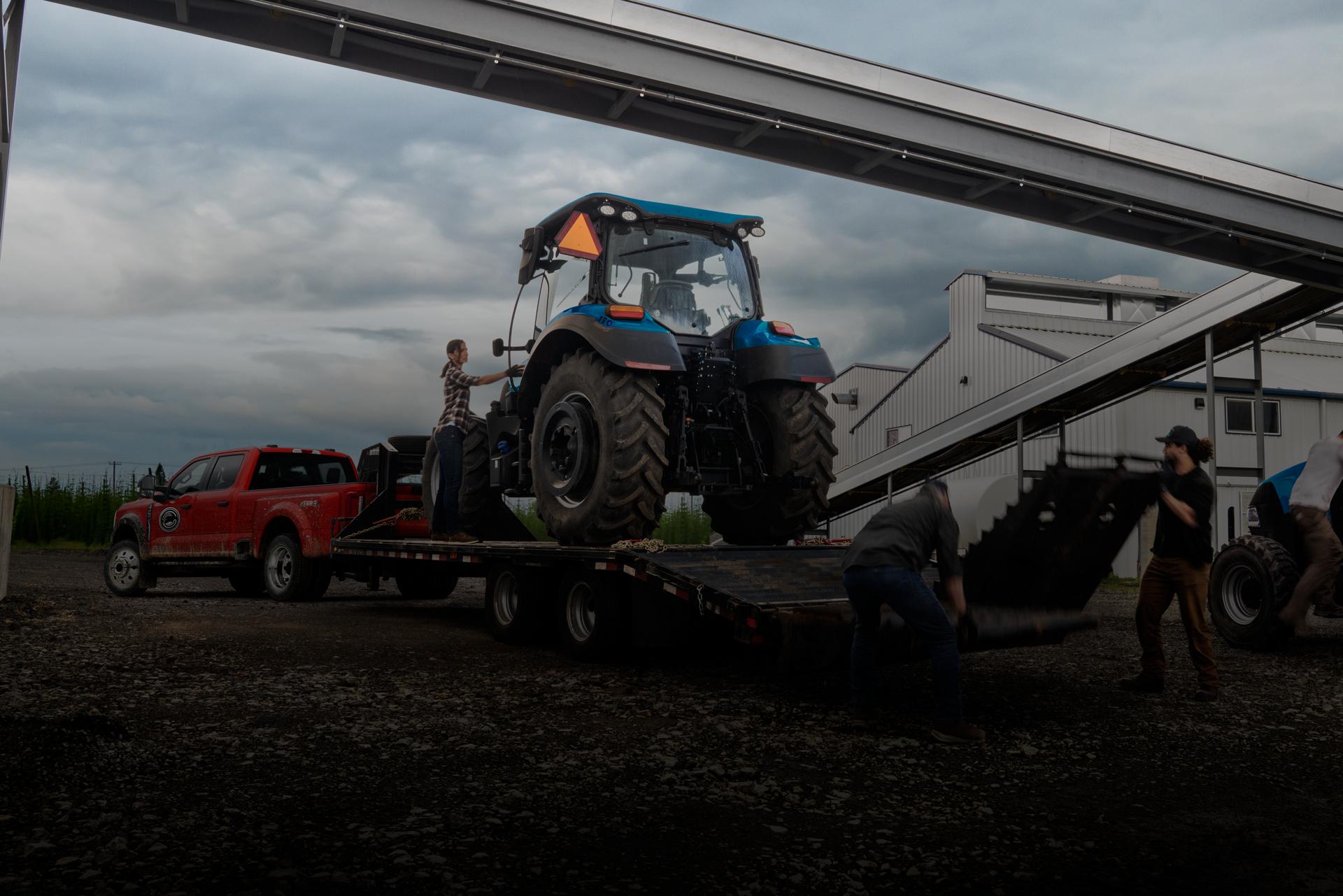 Ford Super Duty® F-450® XL 2026 en rouge course tirant une remorque transportant un gros tracteur