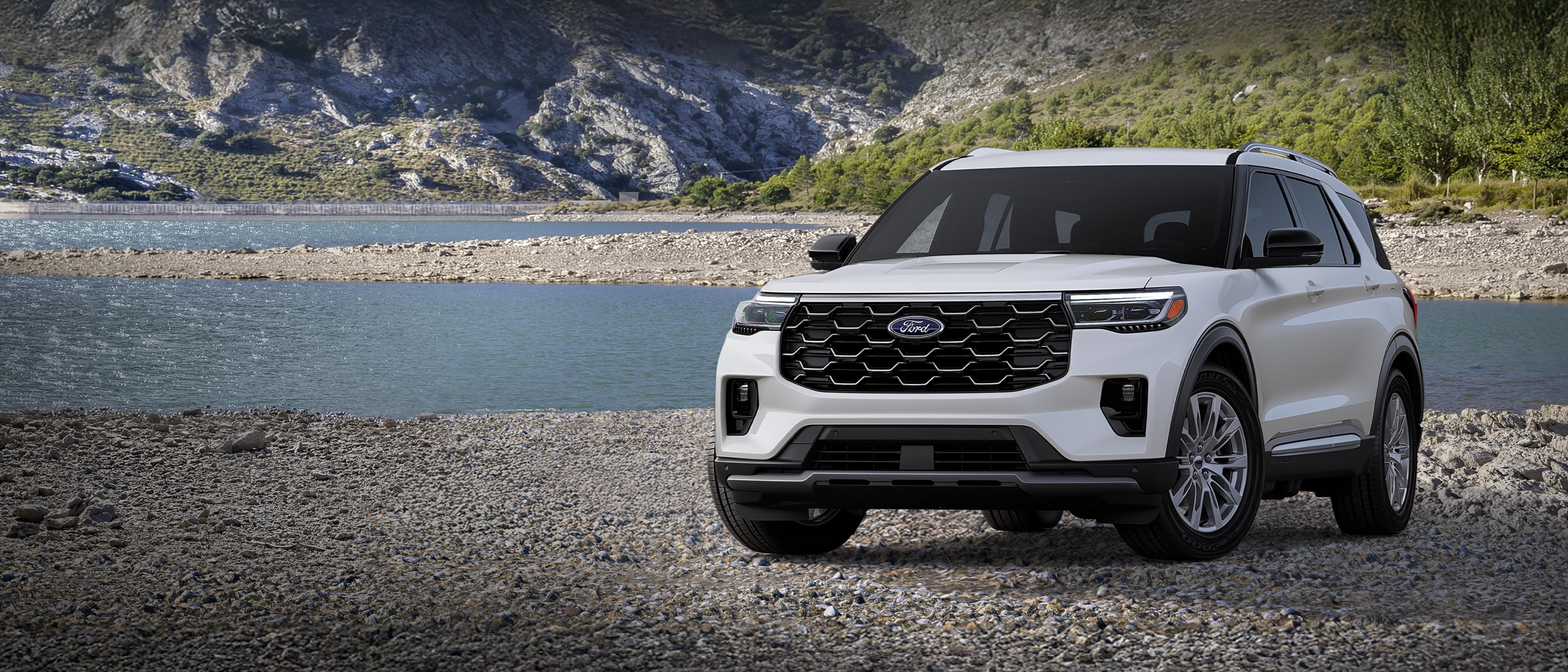 Un modèle Ford Explorer® Platinum™ 2026 stationné sur une étendue rocheuse, près d’un lac de montagne