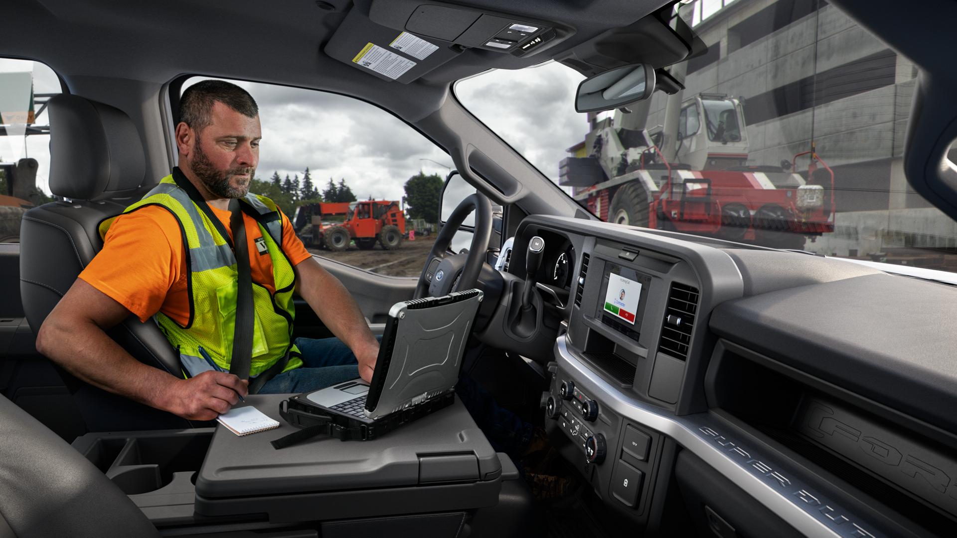 Un travailleur utilisant son ordinateur portable sur la console centrale de la surface de travail intérieure