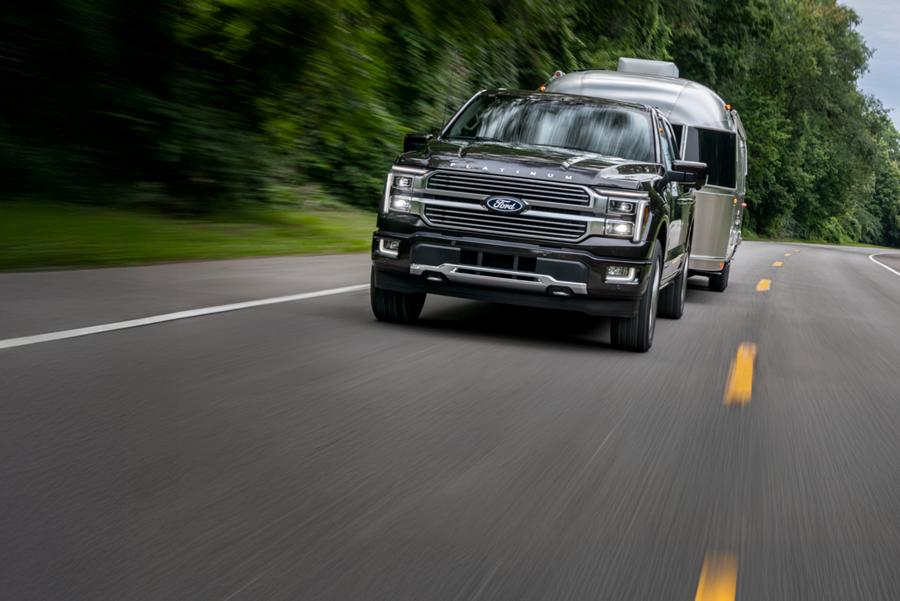 F 150 tractant une remorque sur une autoroute à deux voies.