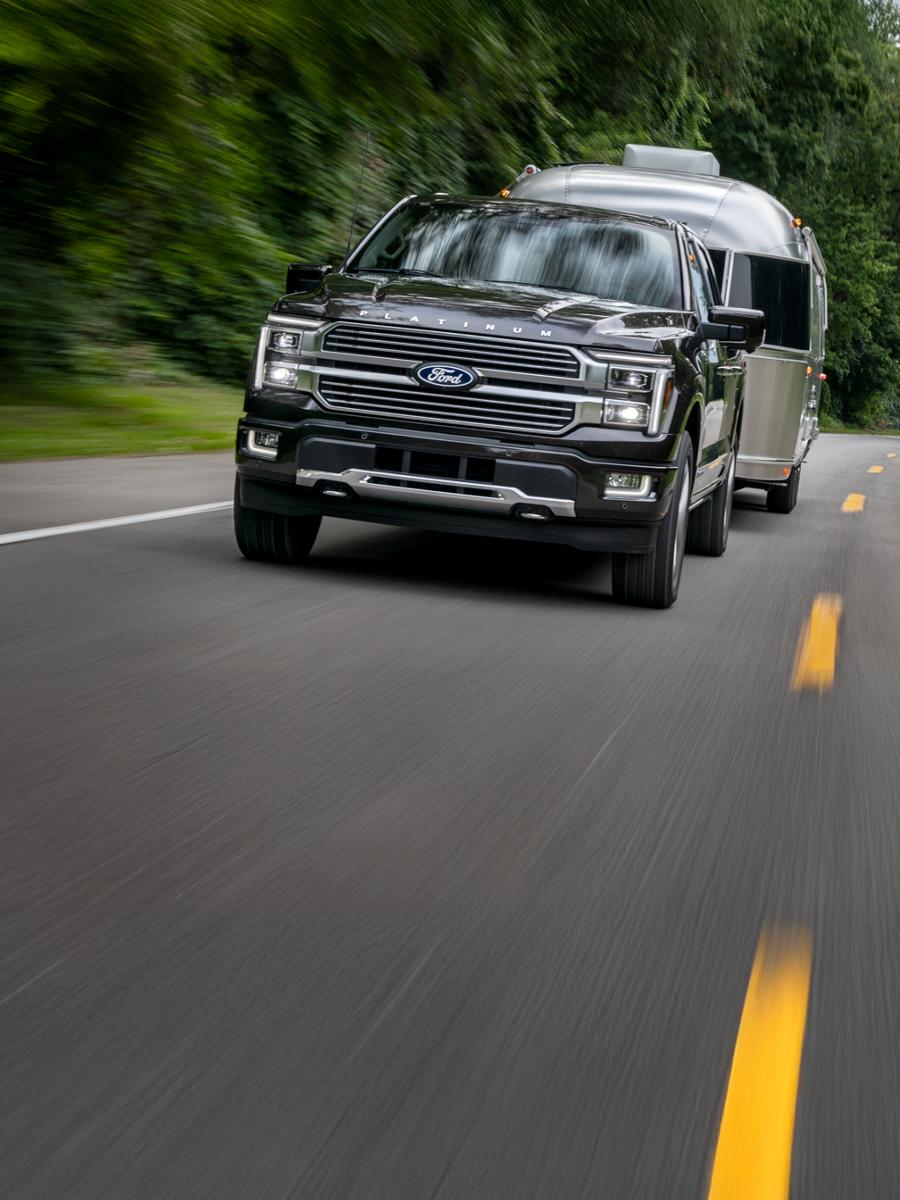 F 150 tractant une remorque sur une autoroute à deux voies.