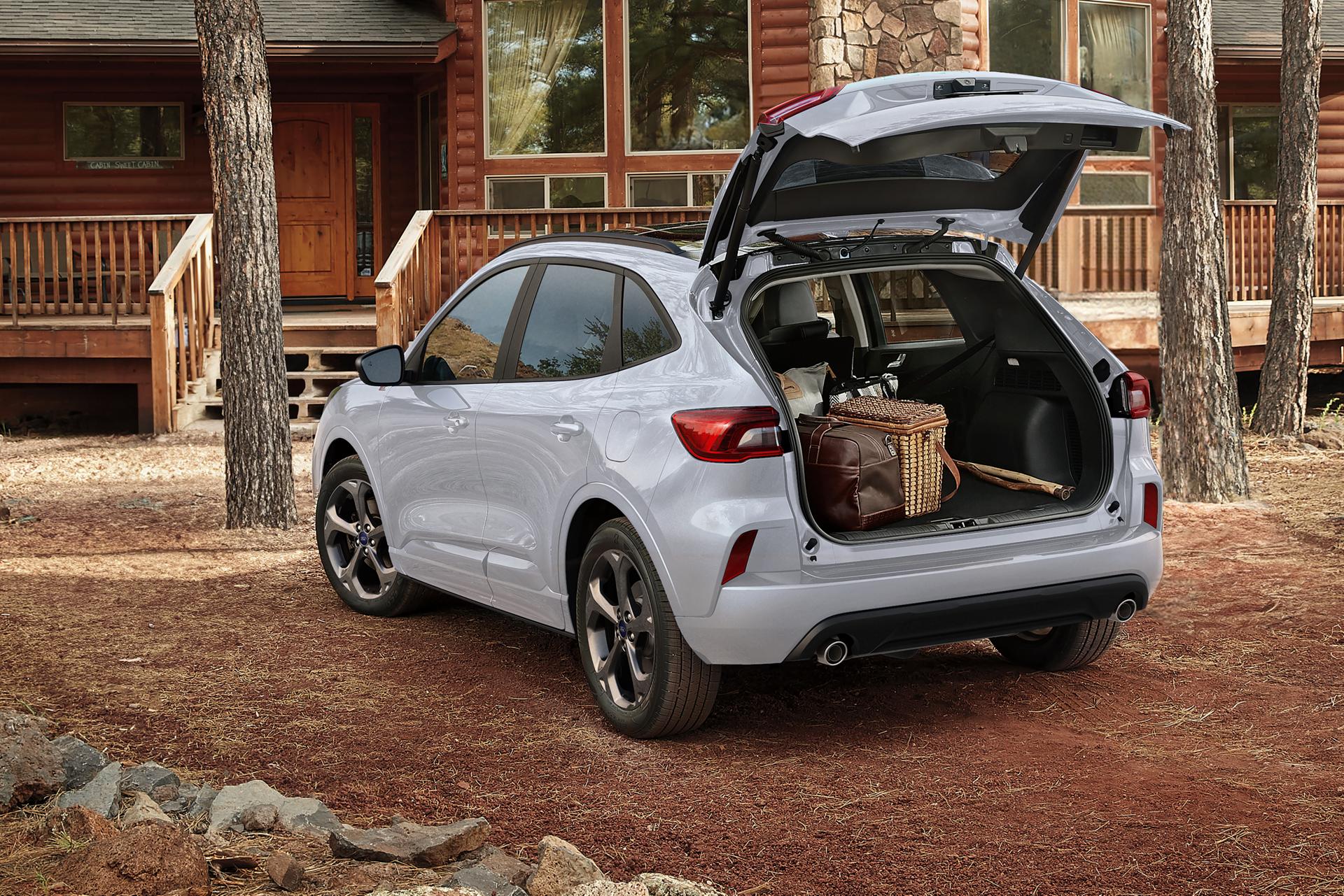 VUS Ford Escape® 2026 stationné devant un chalet avec le hayon électrique ouvert