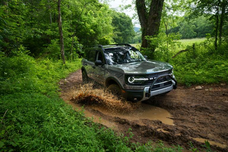 Un Ford Bronco Sport® 2026 roulant sur un chemin de terre dans les bois