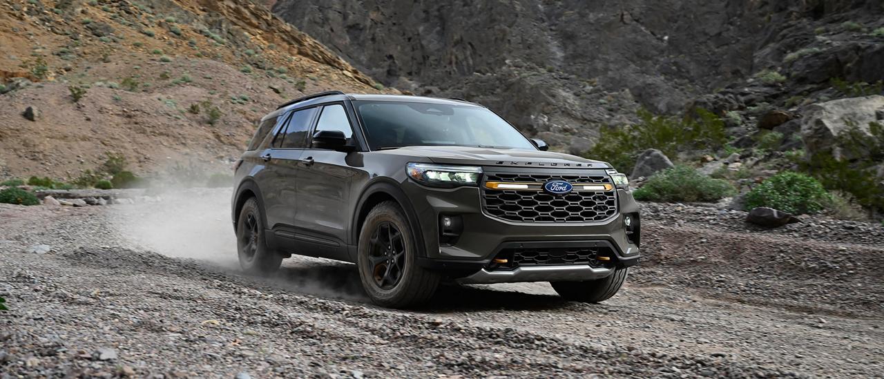 Un VUS Ford Explorer® Tremor® 2027 soulevant de la poussière alors qu’il roule sur un chemin de gravier dans les collines